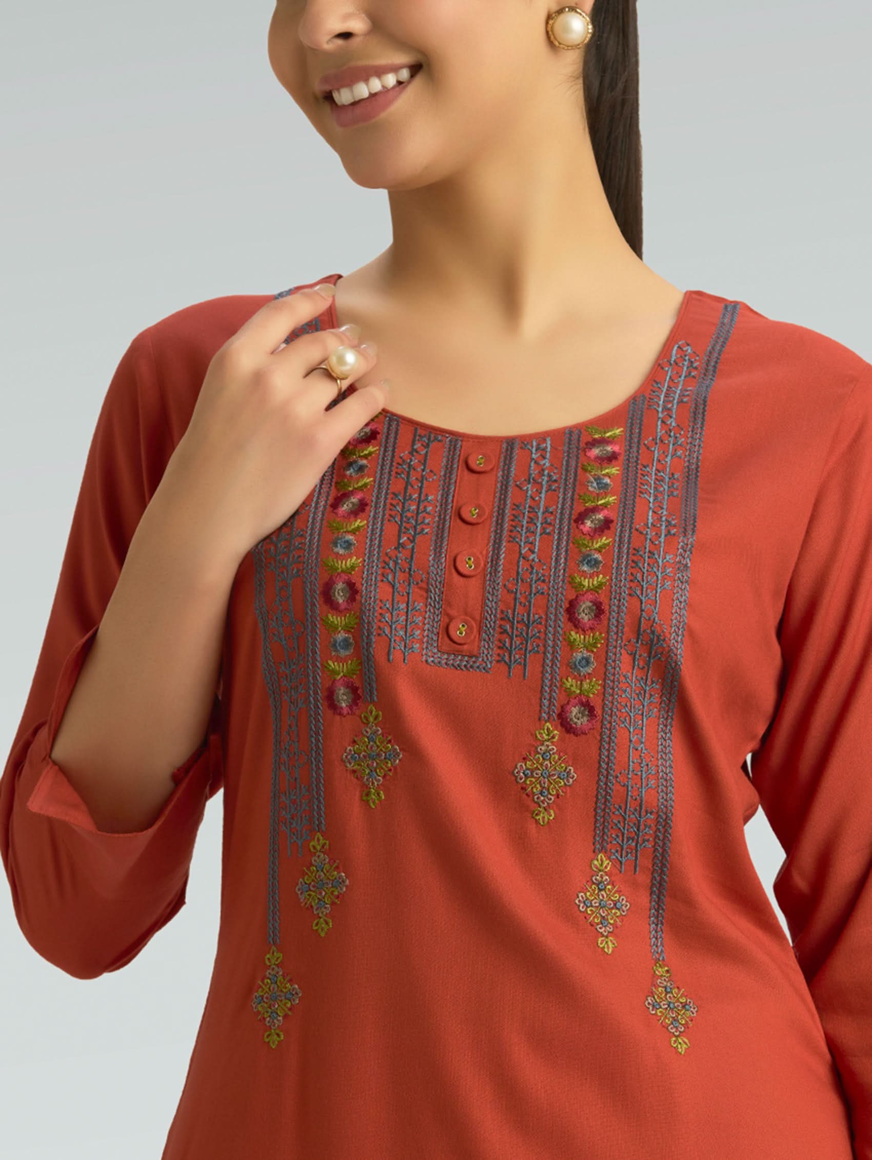 Red kurta with intricate embroidery on a plain background