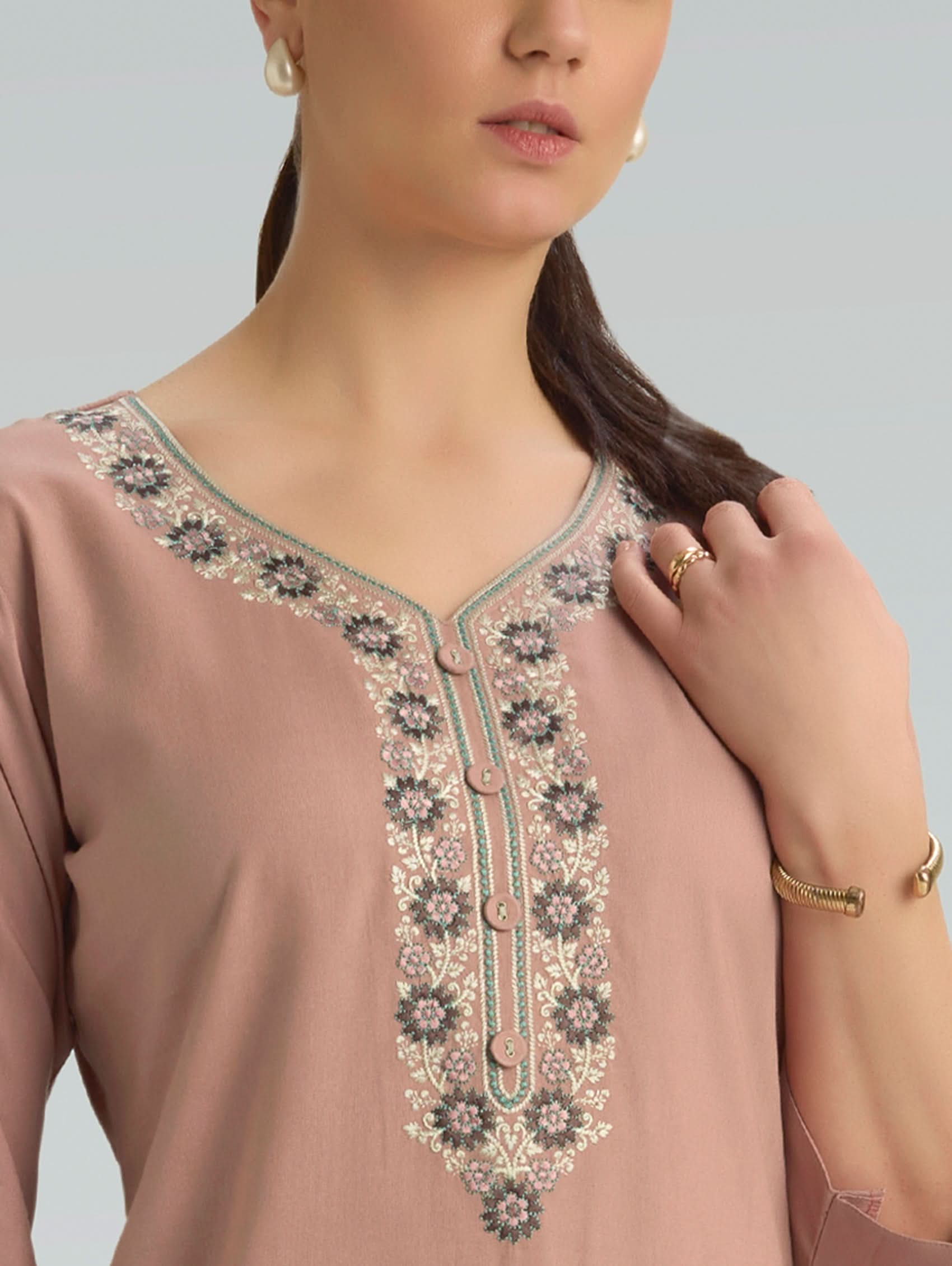 Close-up of a brown embroidered top with a plain background