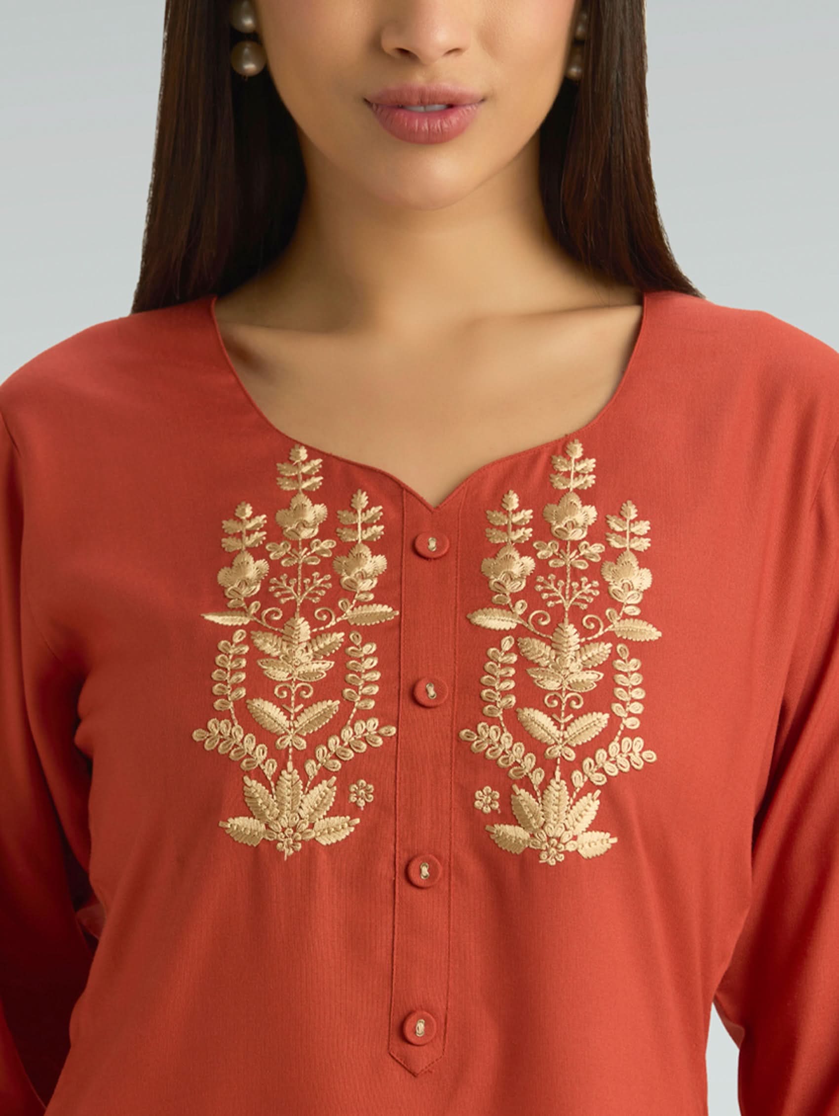 Red kurta with gold embroidery on a plain background