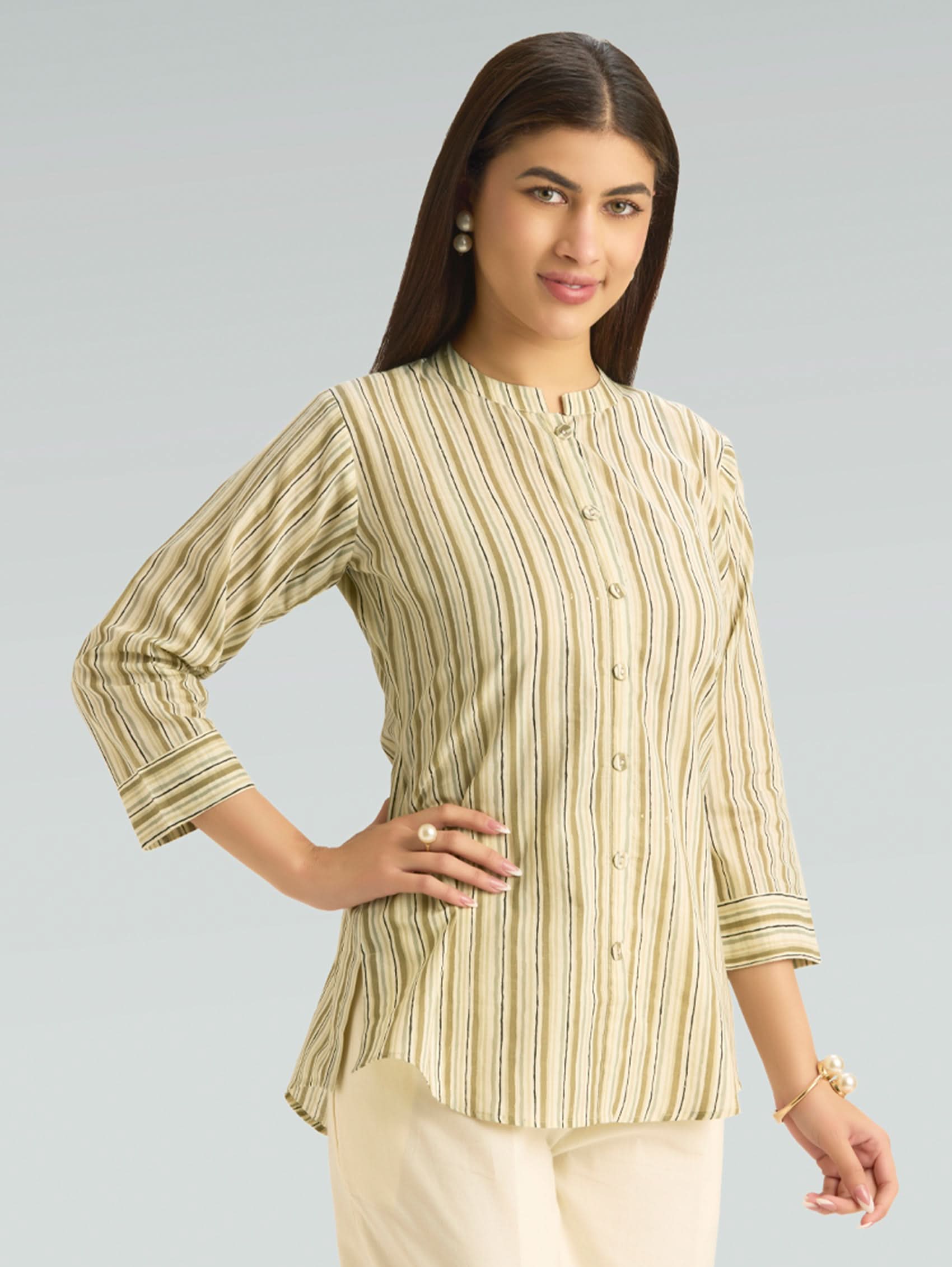 Woman wearing a green and white striped shirt against a gray background