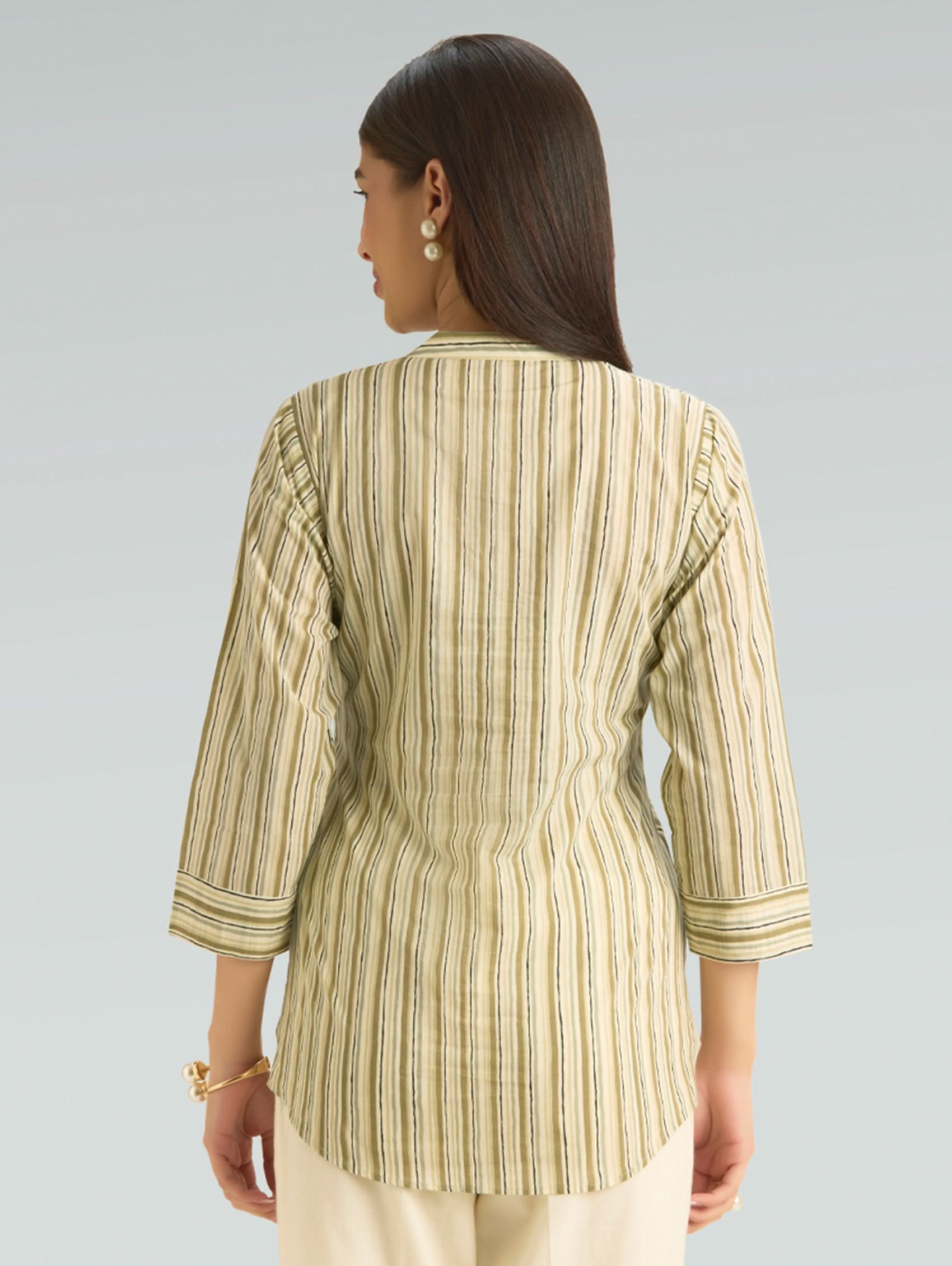 Woman wearing a striped shirt with a plain background