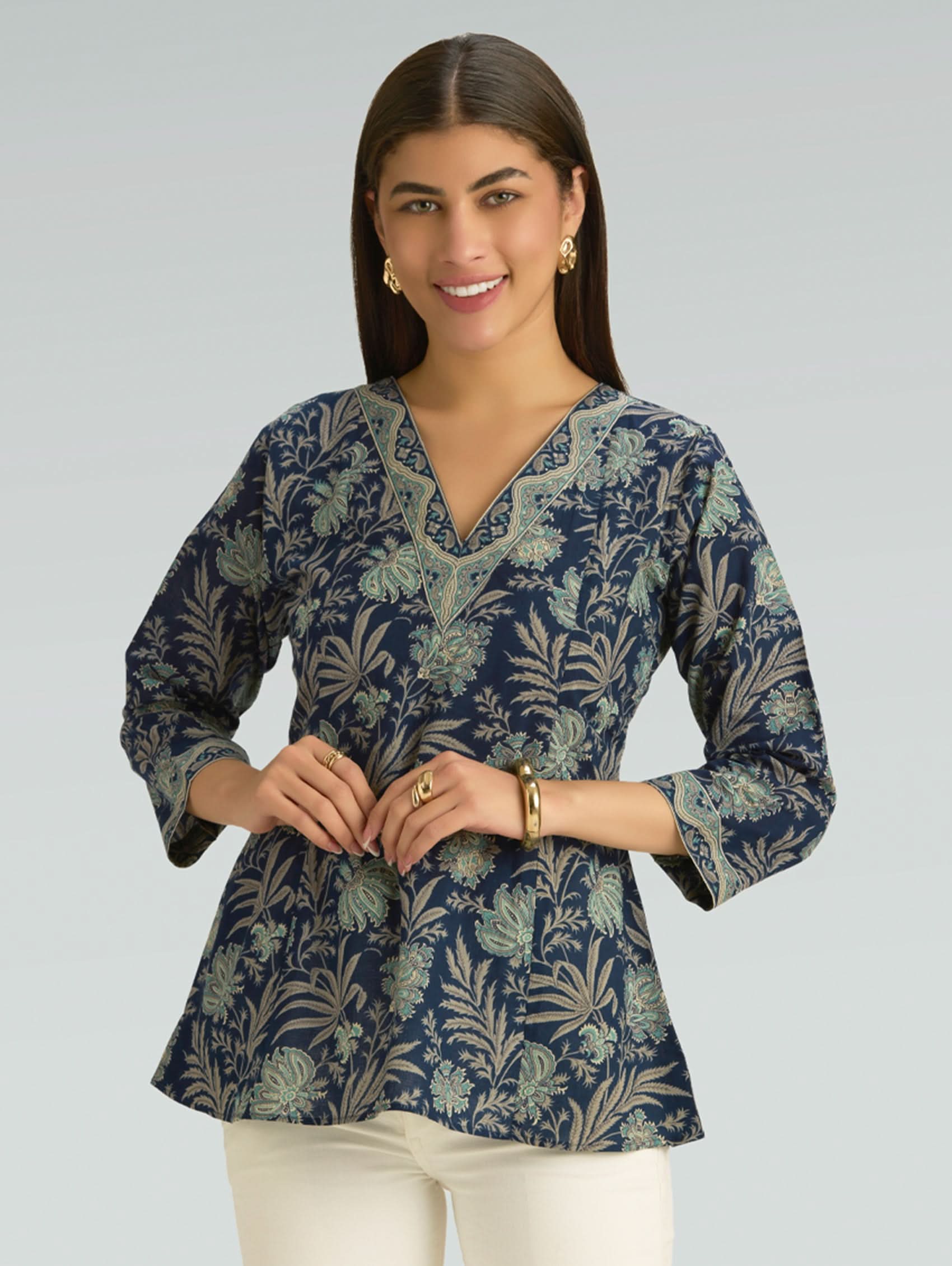 Woman wearing a blue floral patterned blouse against a gray background