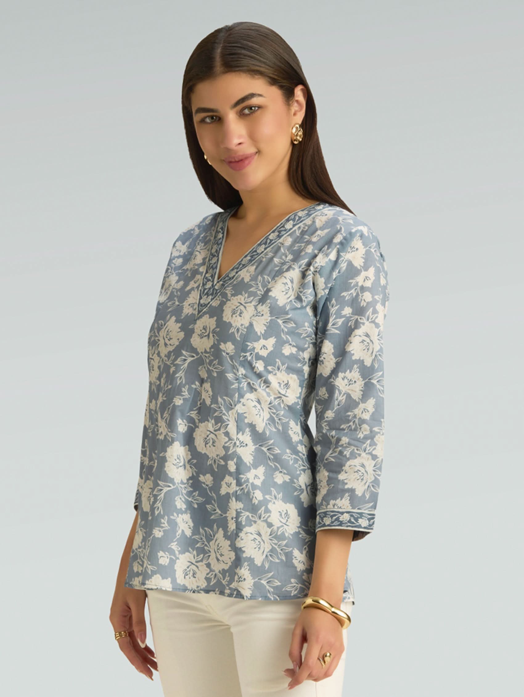 Woman wearing a blue floral blouse against a gray background