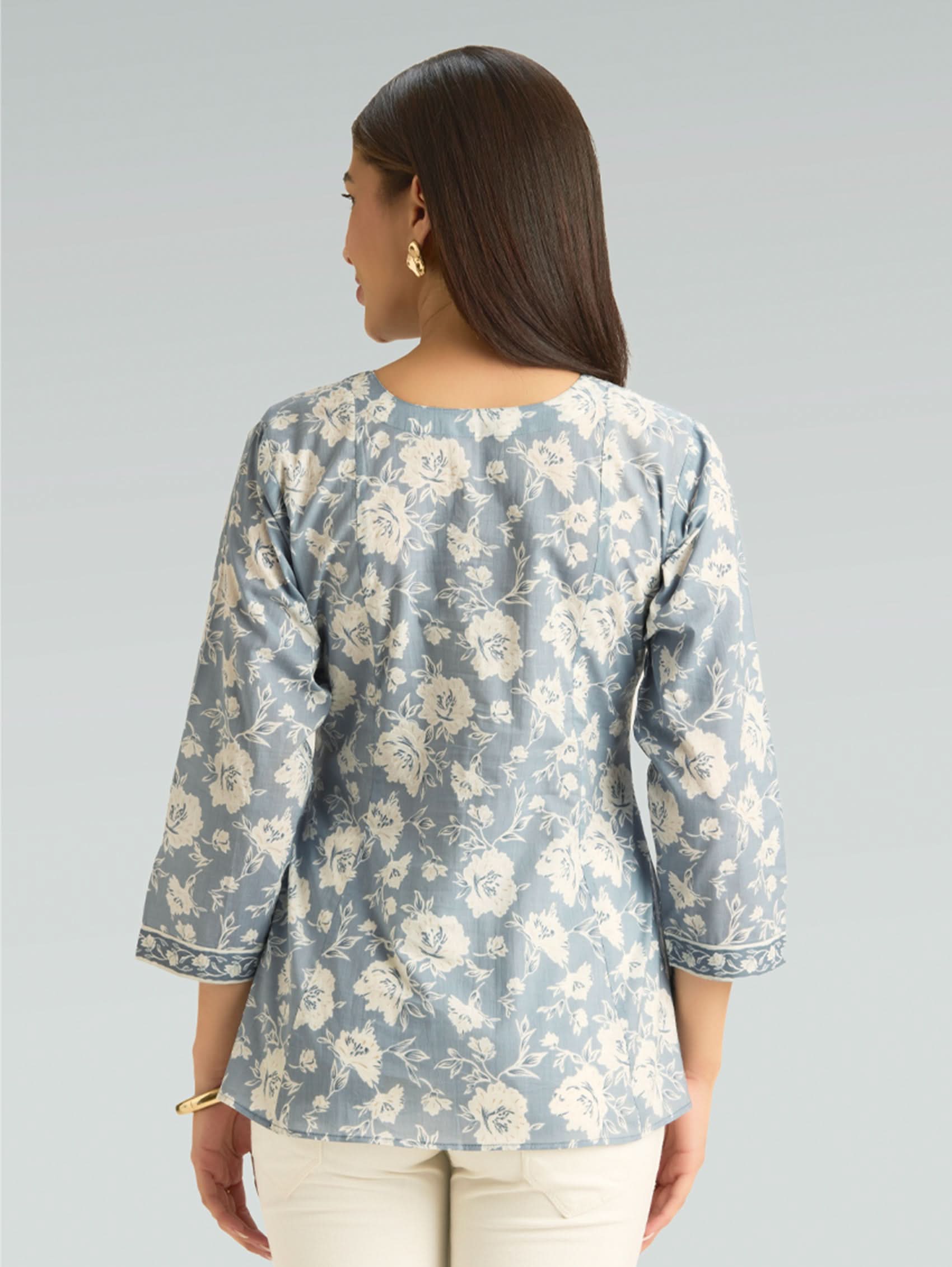 Woman wearing a floral blouse with a gray background