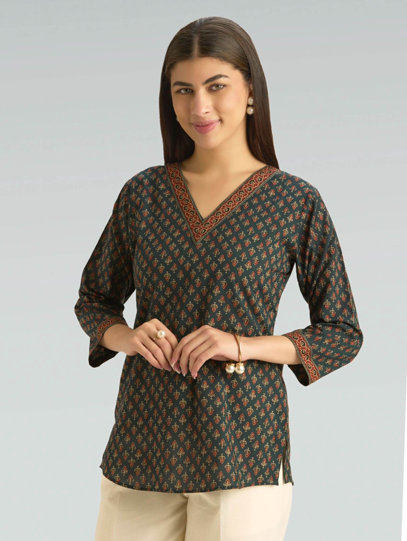 Woman wearing a patterned blouse against a plain background