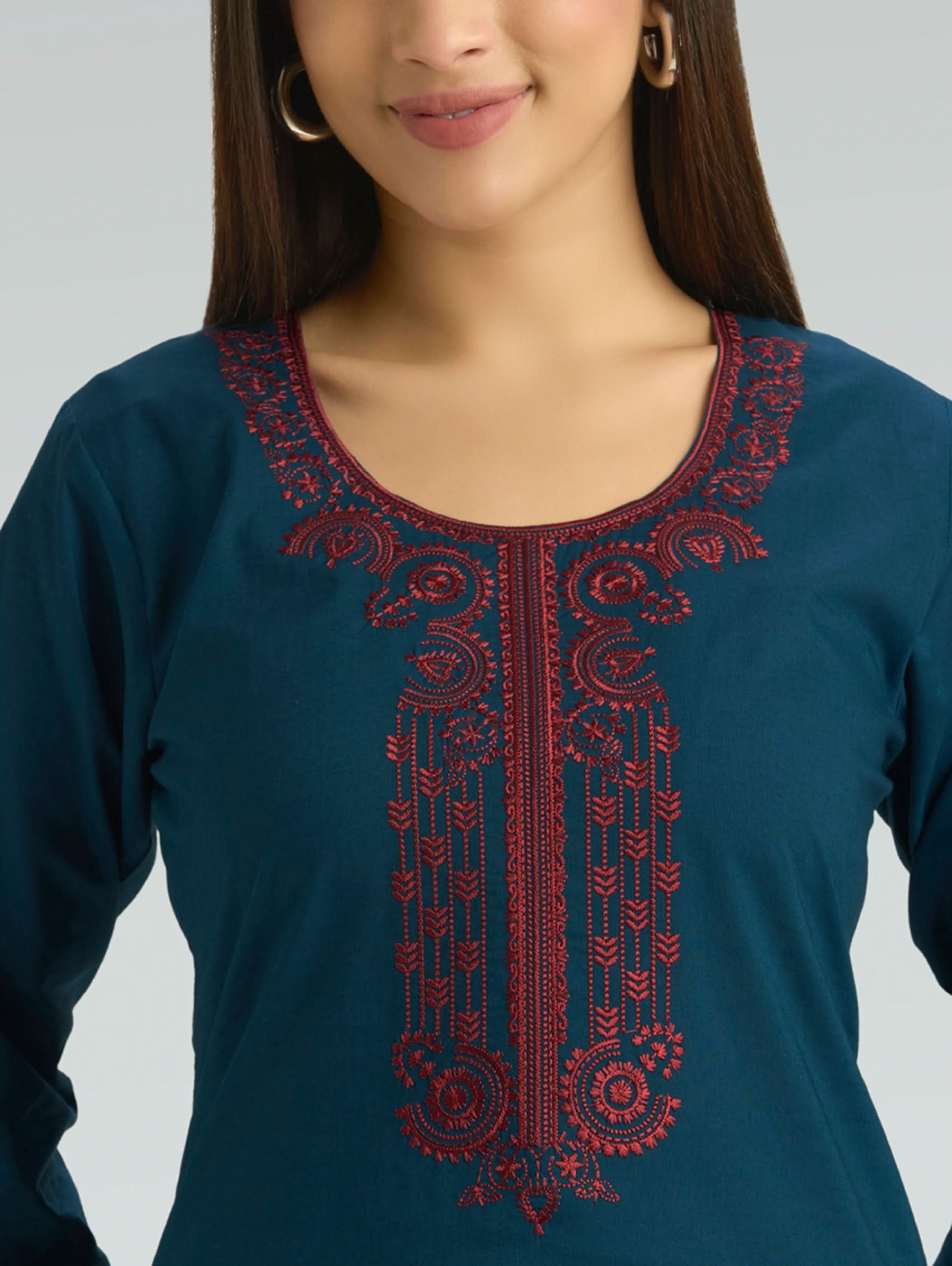 Blue top with red embroidery on a plain background