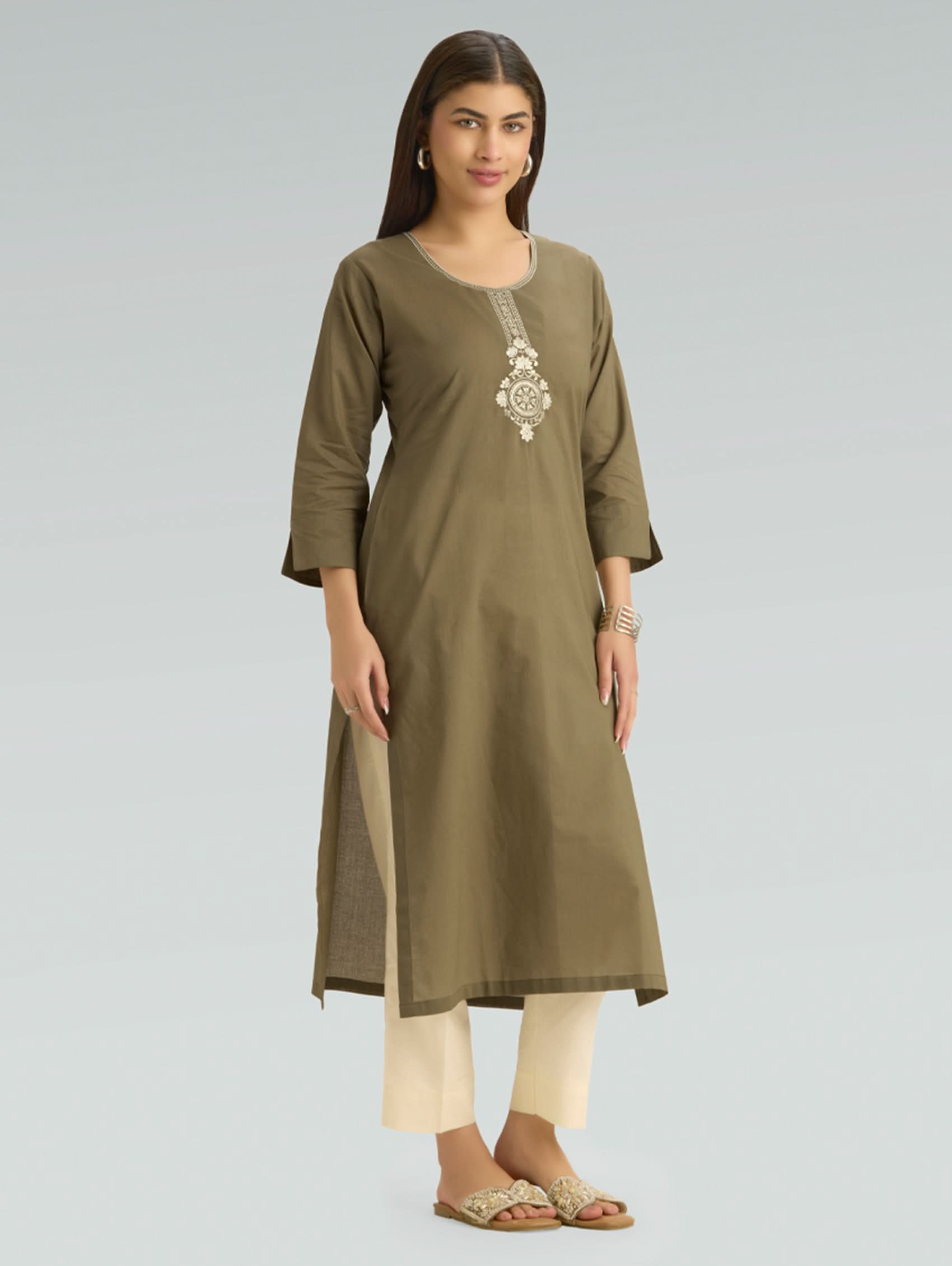 Woman wearing an olive green kurta with white embroidery on a gray background
