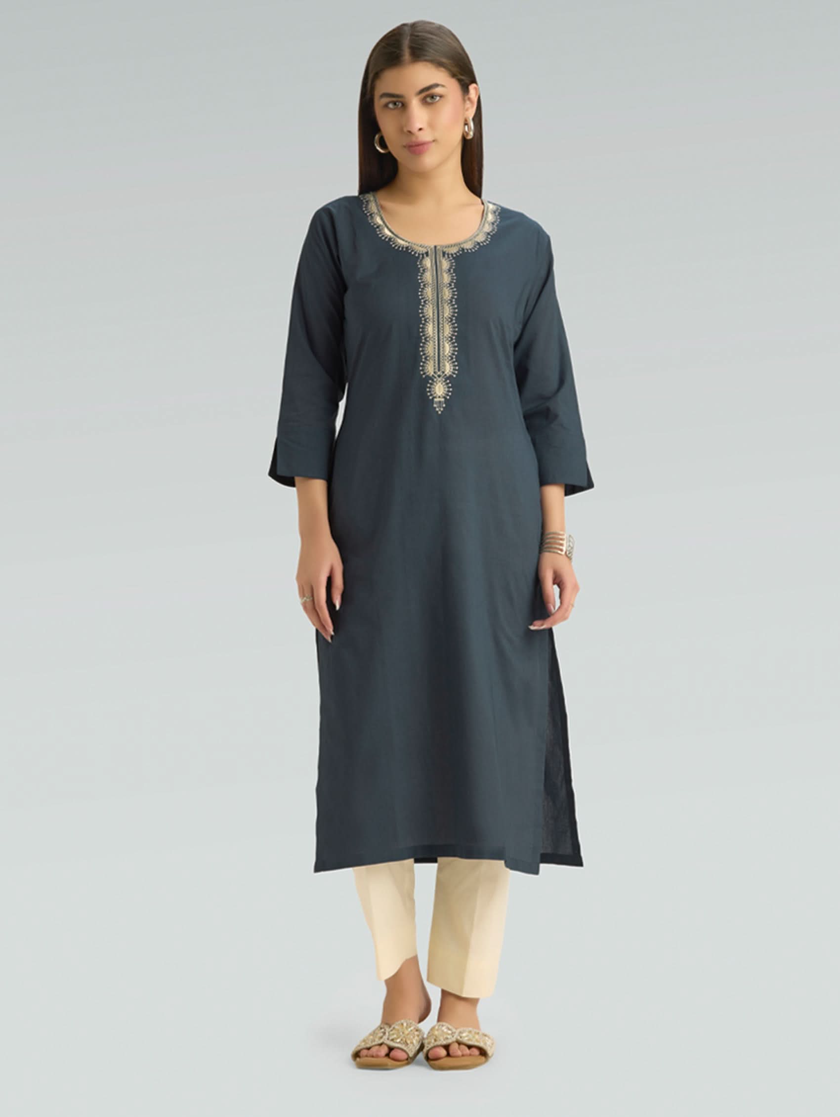 Woman wearing a dark gray kurta with embroidery on a light gray background