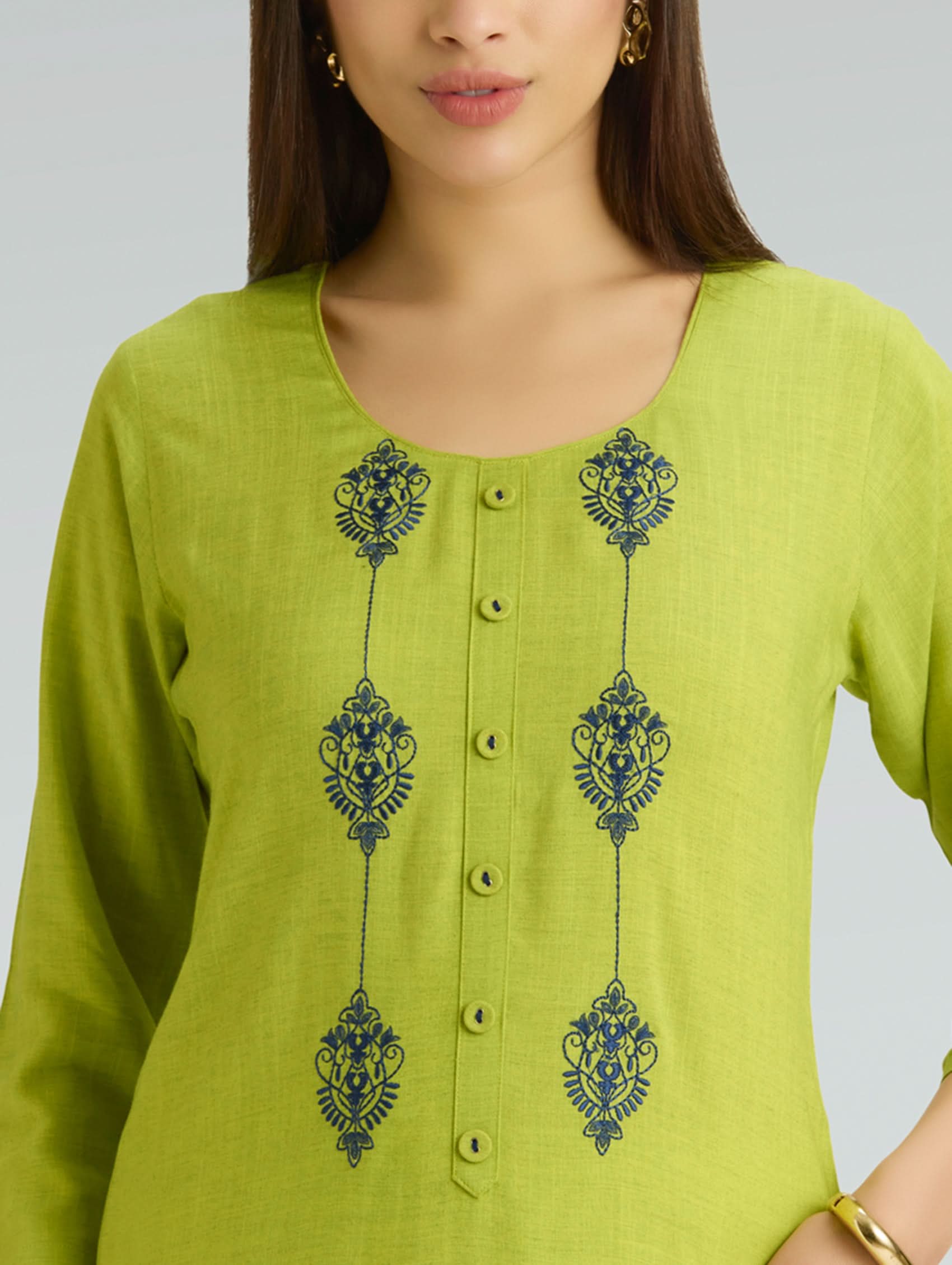 Green kurta with blue embroidery on a plain background