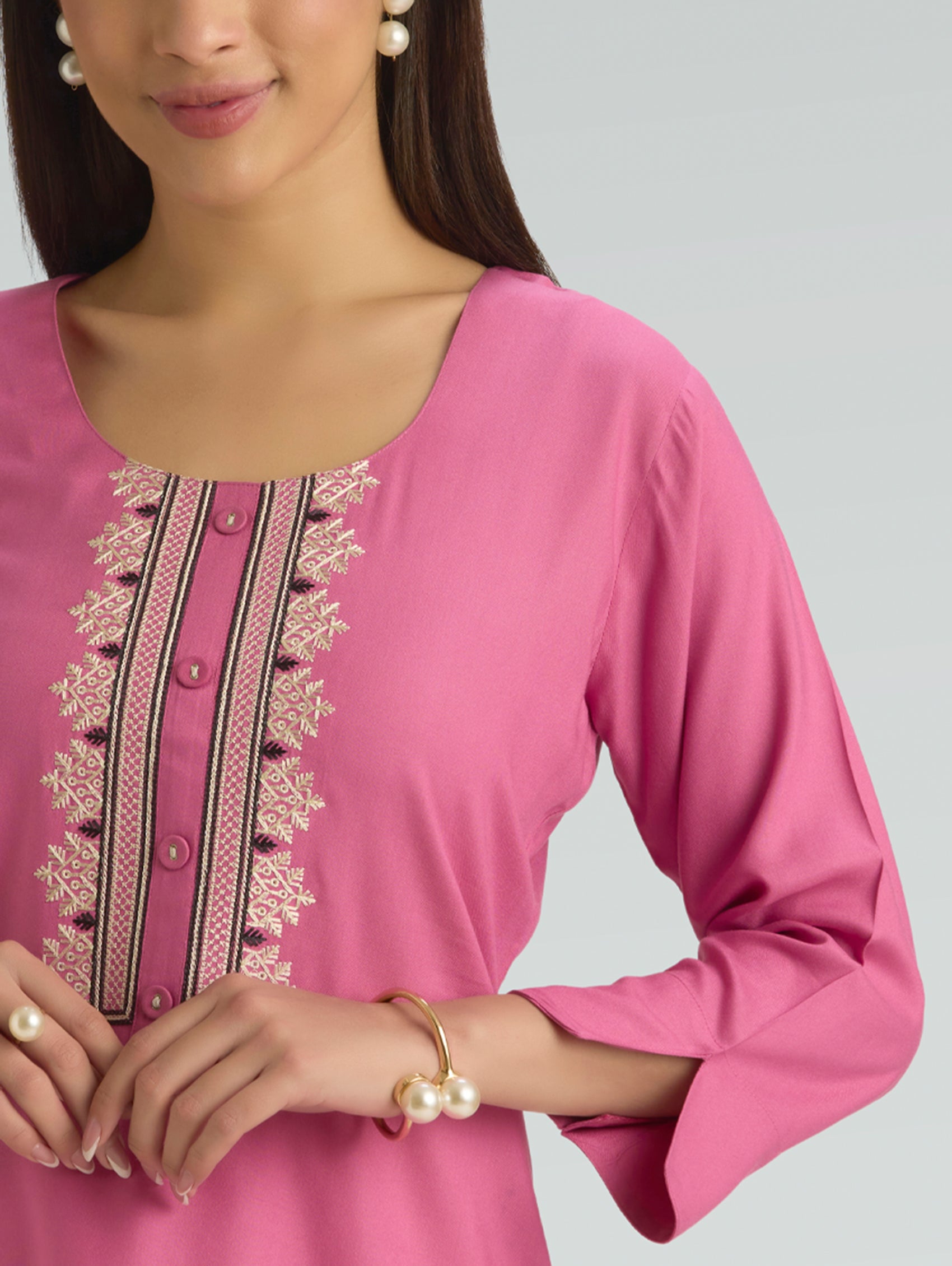 Pink kurta with intricate embroidery on a grey background