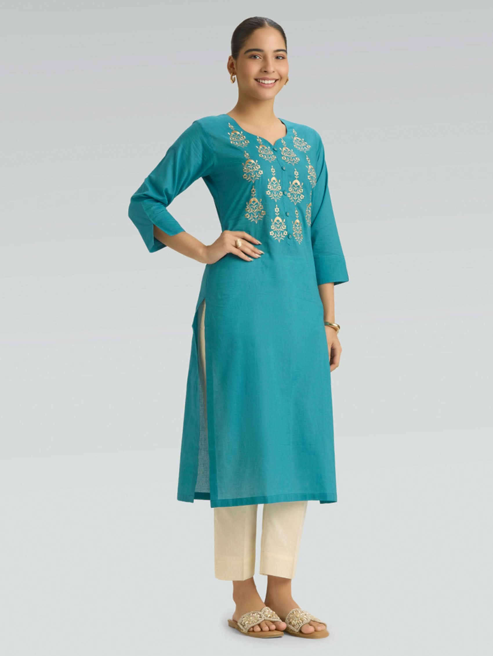 Woman wearing an Iris Blue embroidered kurta with white pants on a light gray background