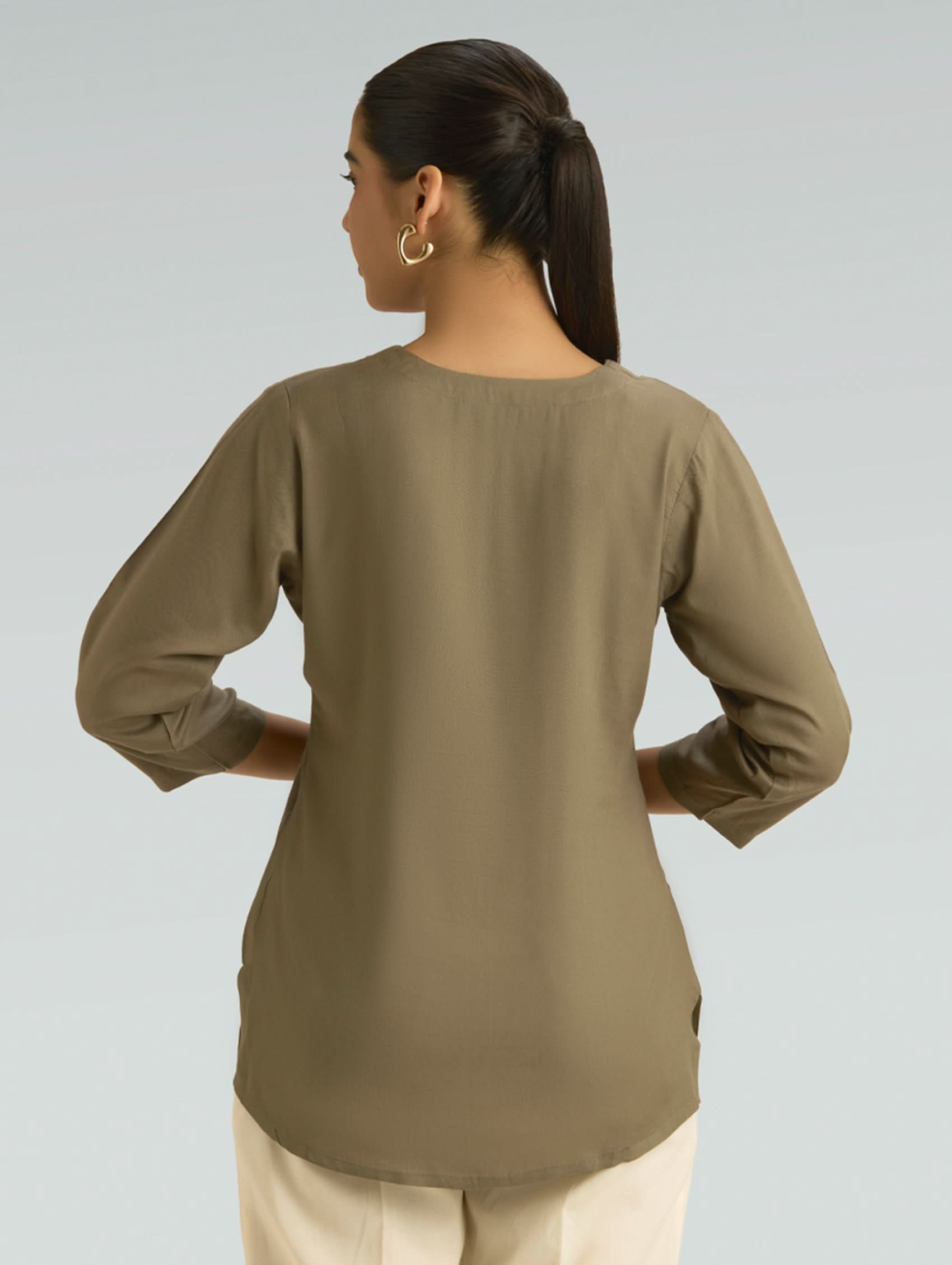 Woman wearing a green blouse against a gray background