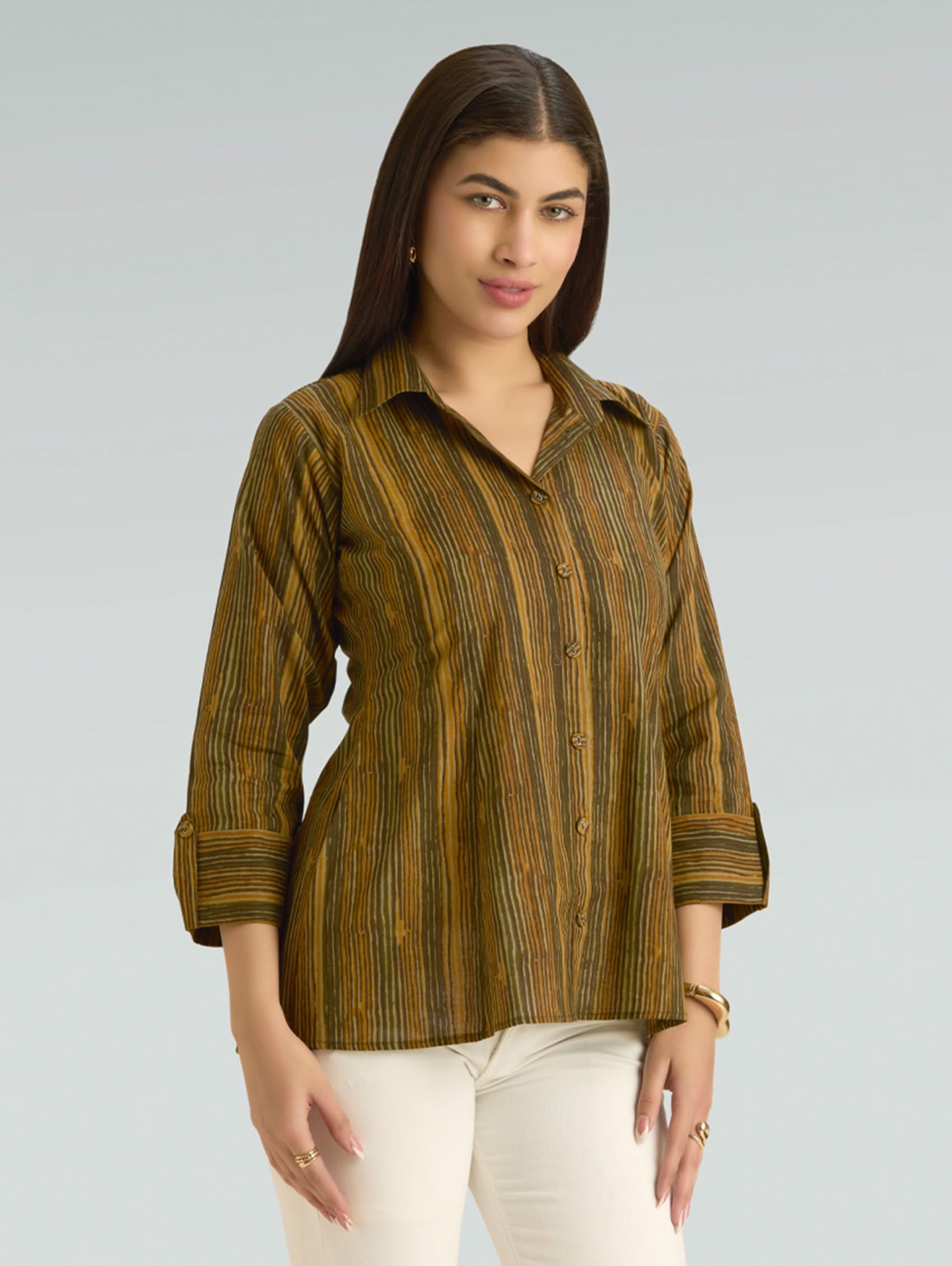 Woman wearing a green and brown striped shirt against a gray background