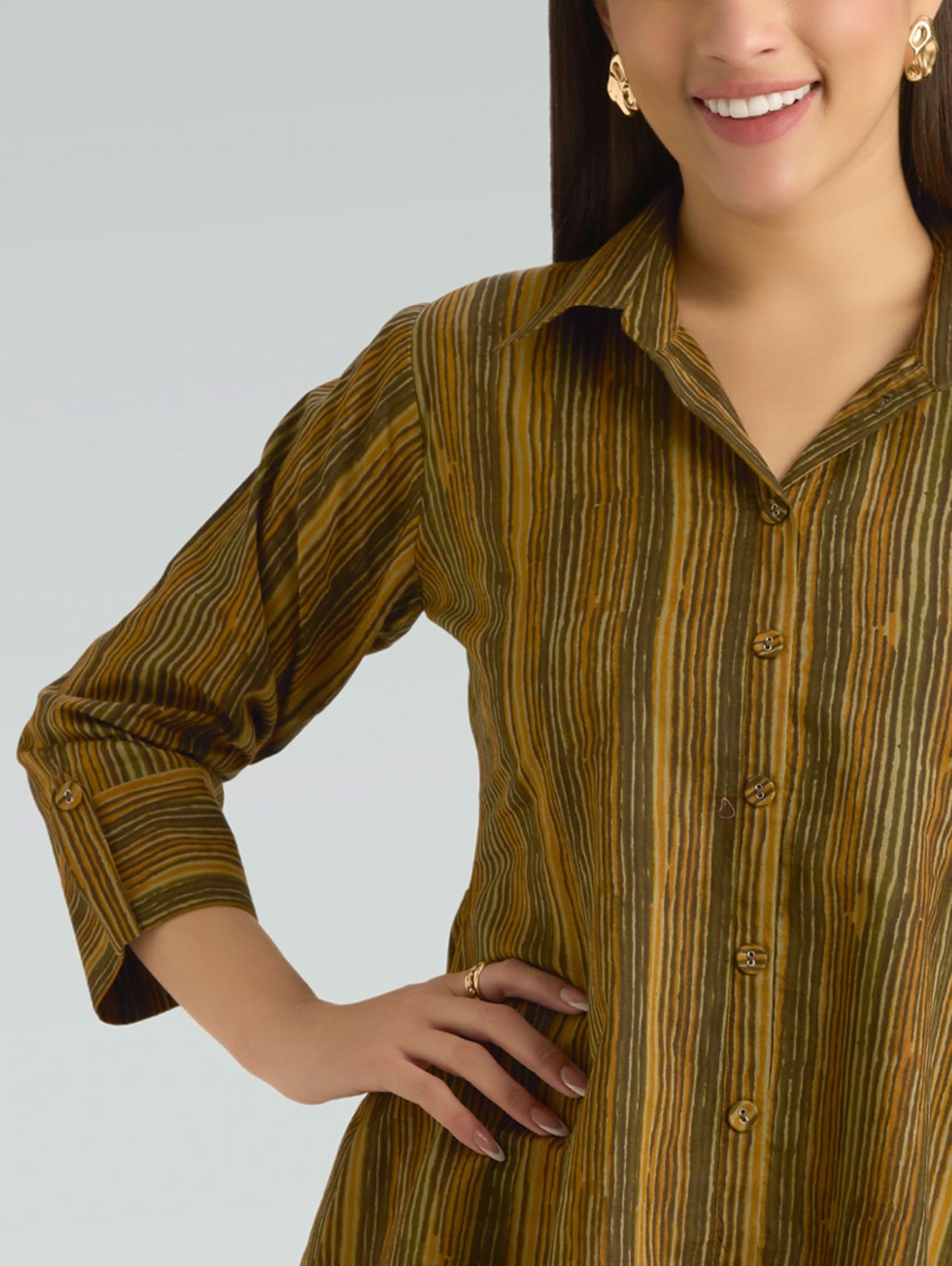 Woman wearing a brown striped shirt against a gray background