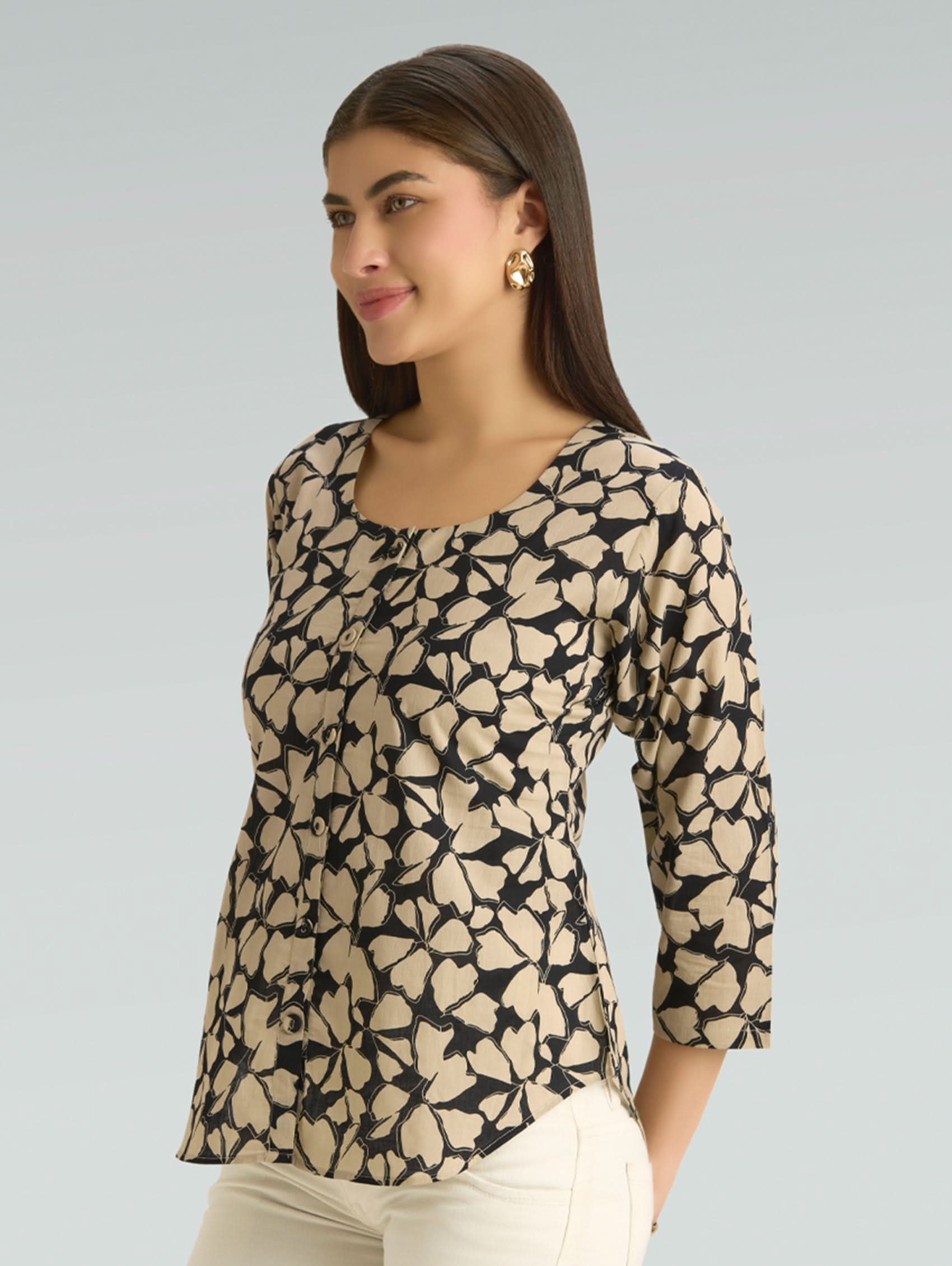 Woman wearing a patterned top with a plain background