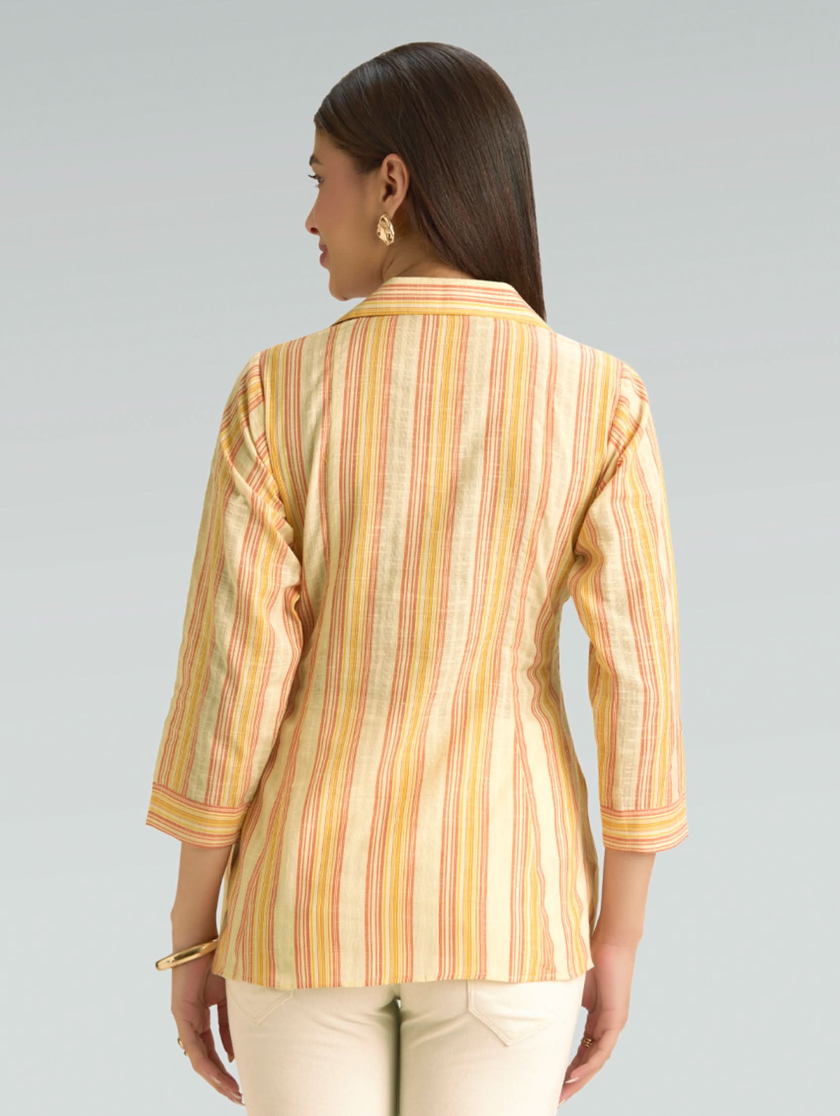 Woman wearing a striped shirt with a neutral background