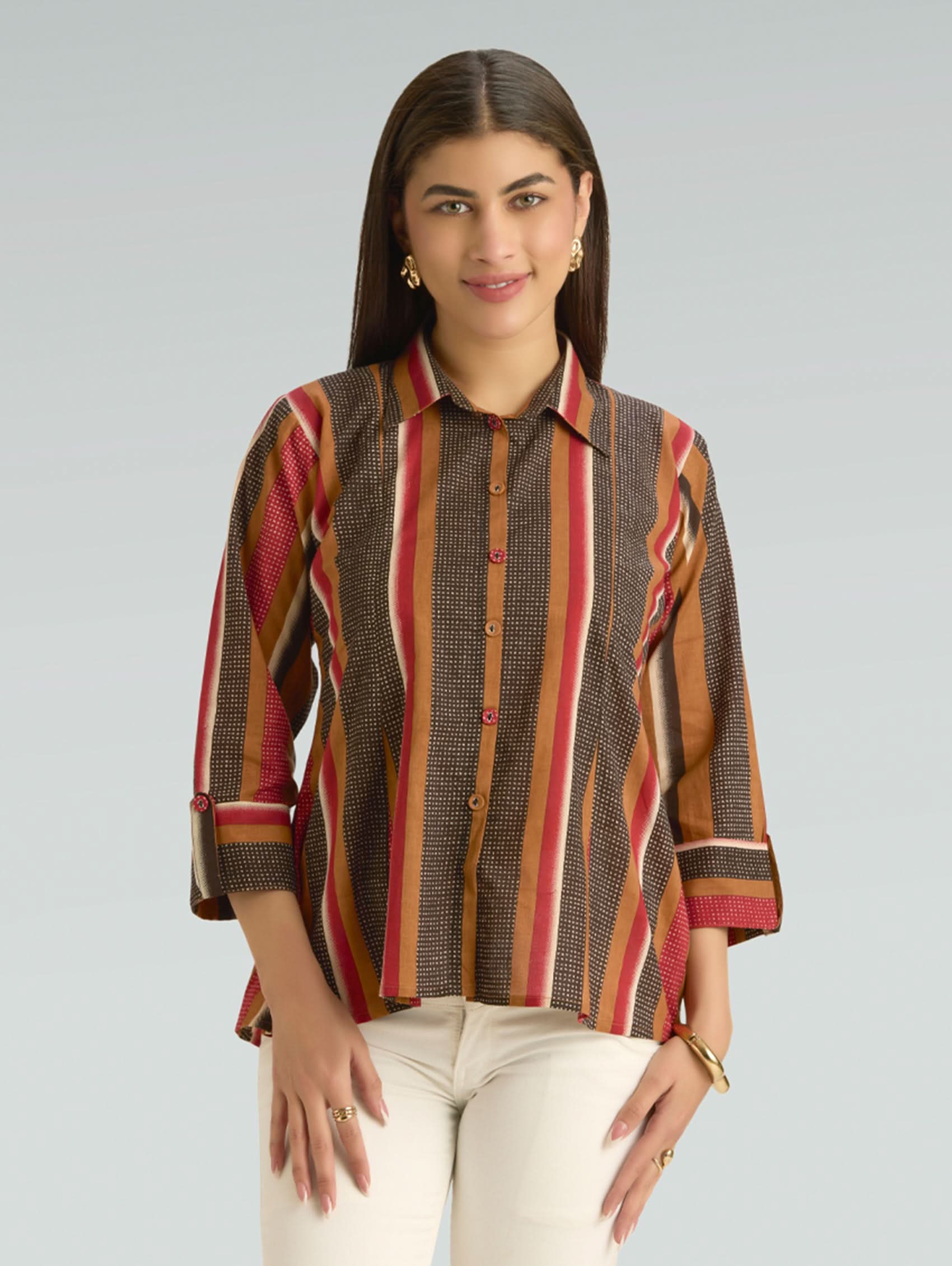 Woman wearing a patterned shirt with a plain background