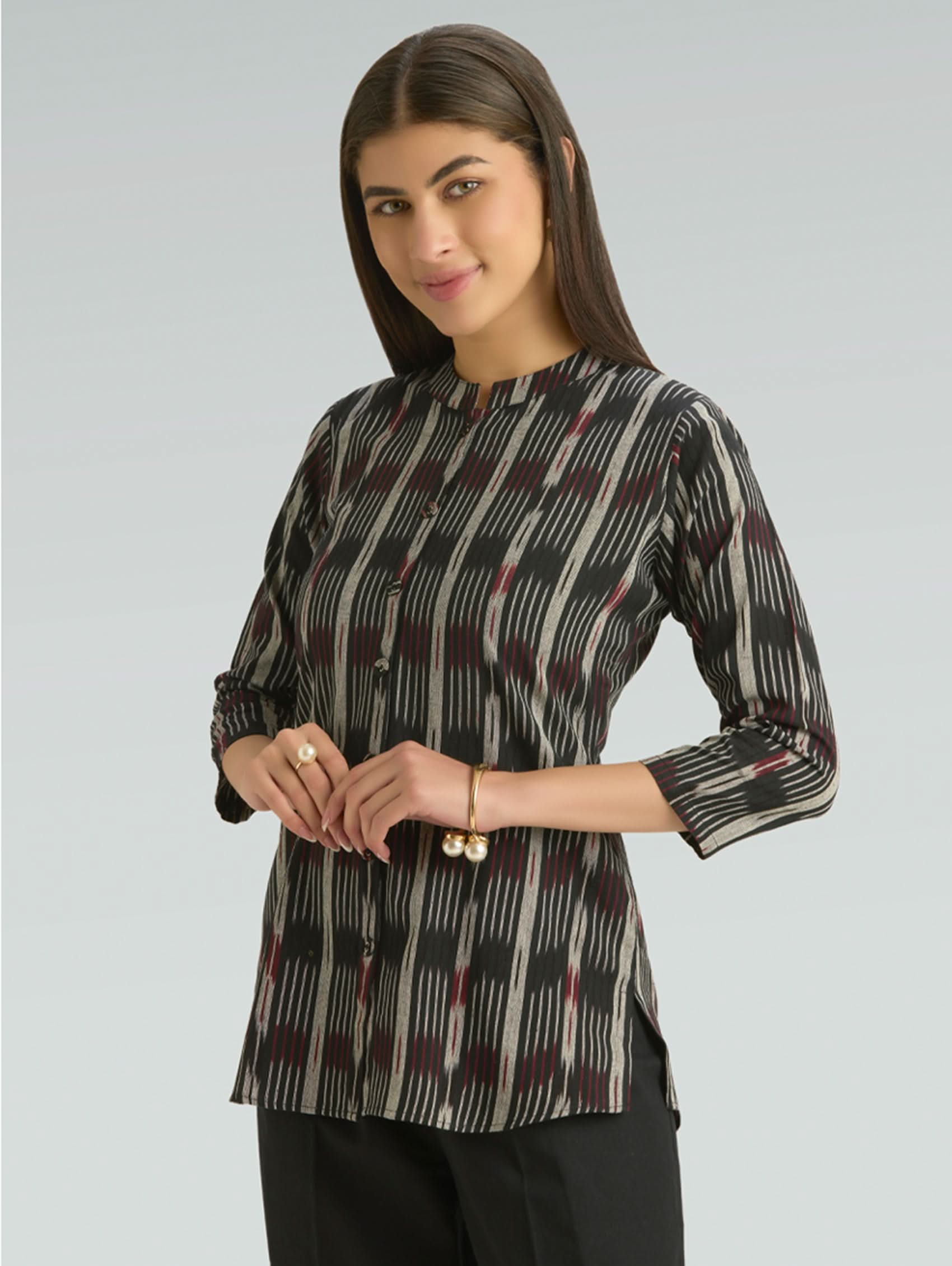 Woman wearing a patterned blouse with a plain background