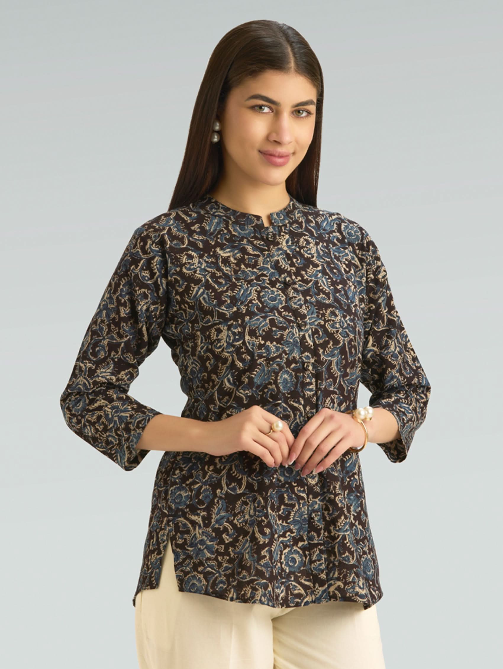 Woman wearing a patterned blouse with a plain background