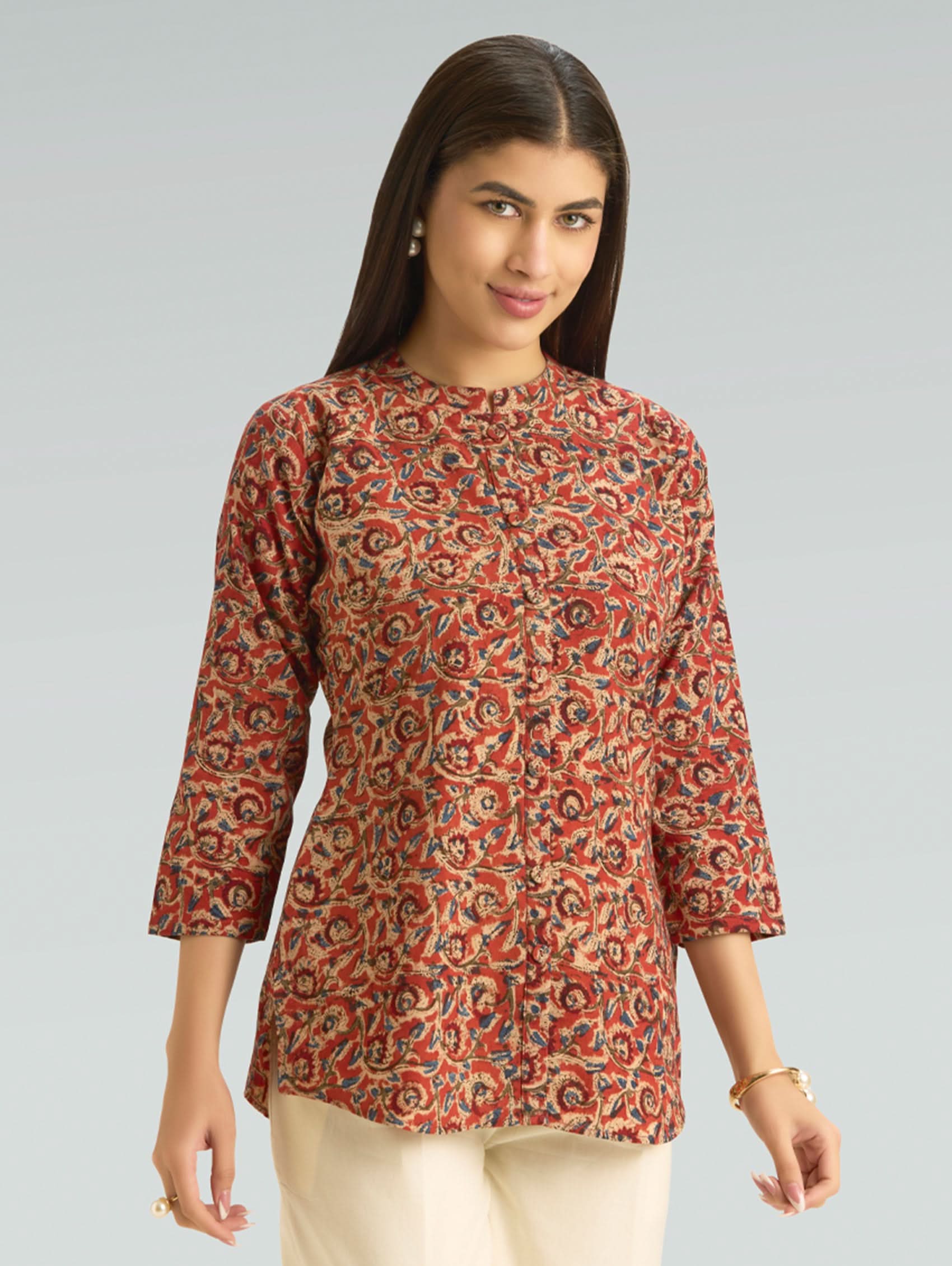 Woman wearing a patterned top on a gray background