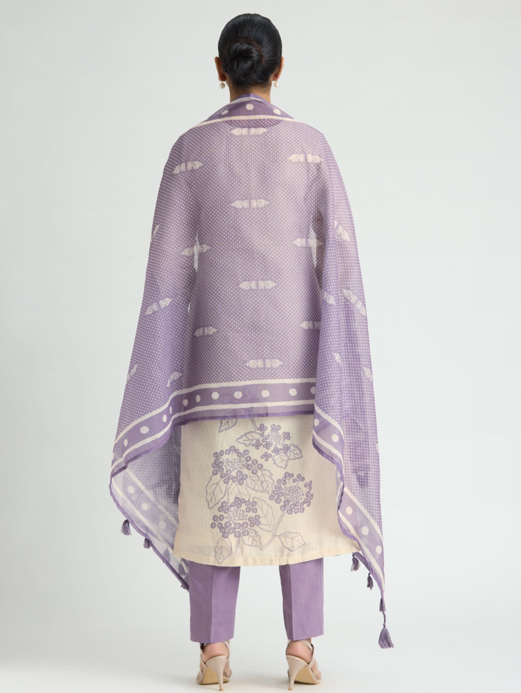 Person wearing a purple traditional outfit with a matching shawl on a white background