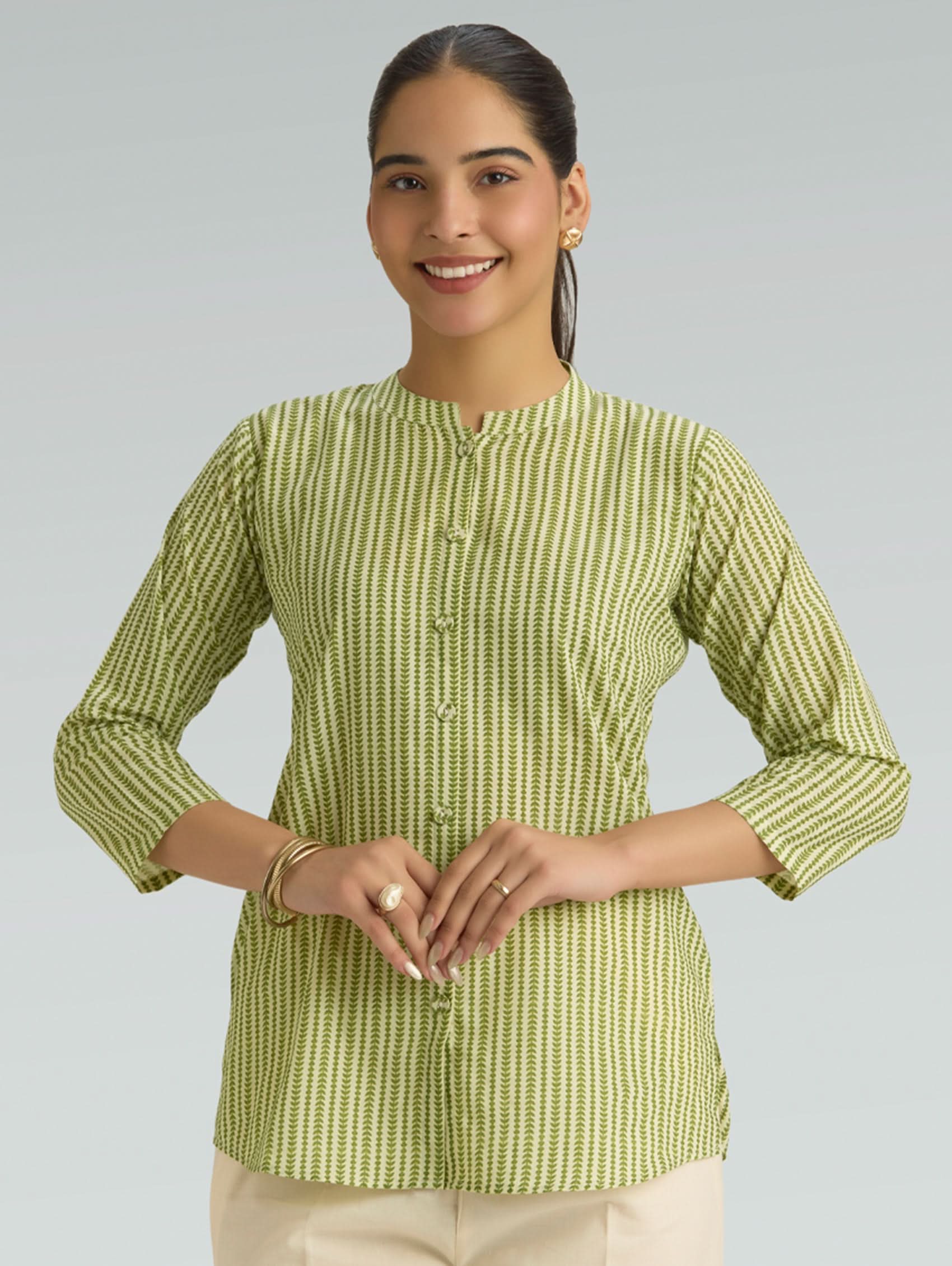 Woman wearing a green and white striped shirt against a gray background