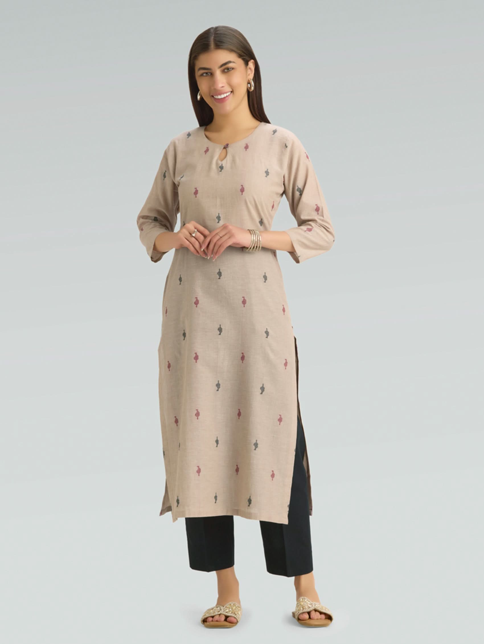 Woman wearing a beige kurta with black pants on a light gray background