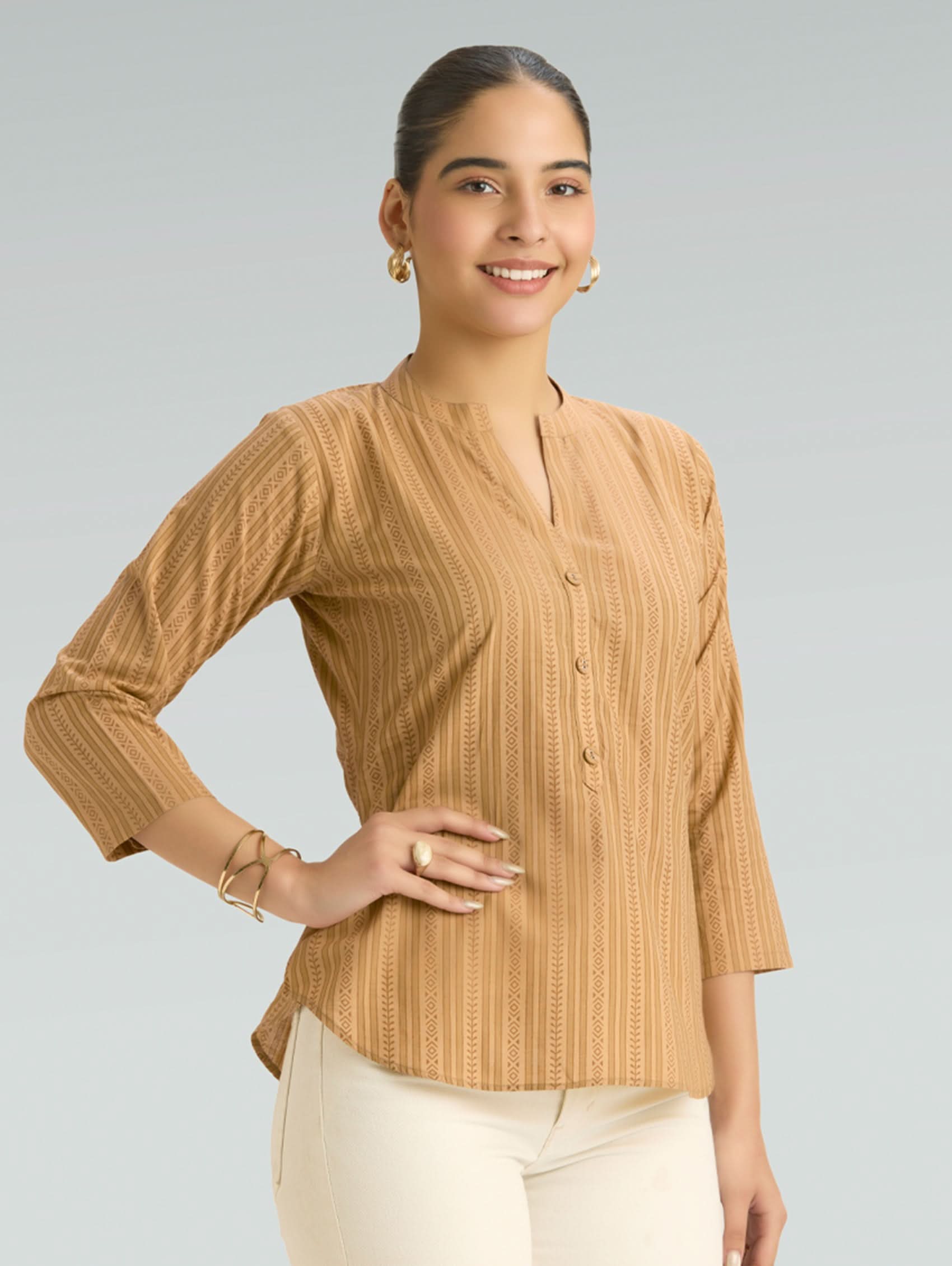 Woman wearing a beige blouse with a plain background