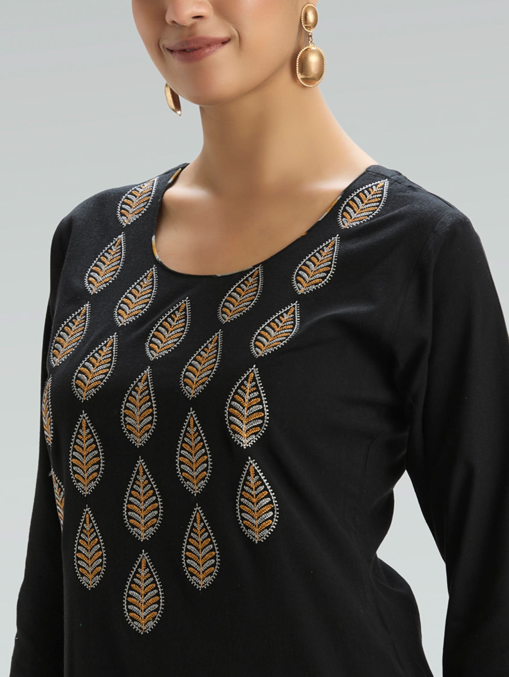 Black dress with gold leaf patterns on a gray background