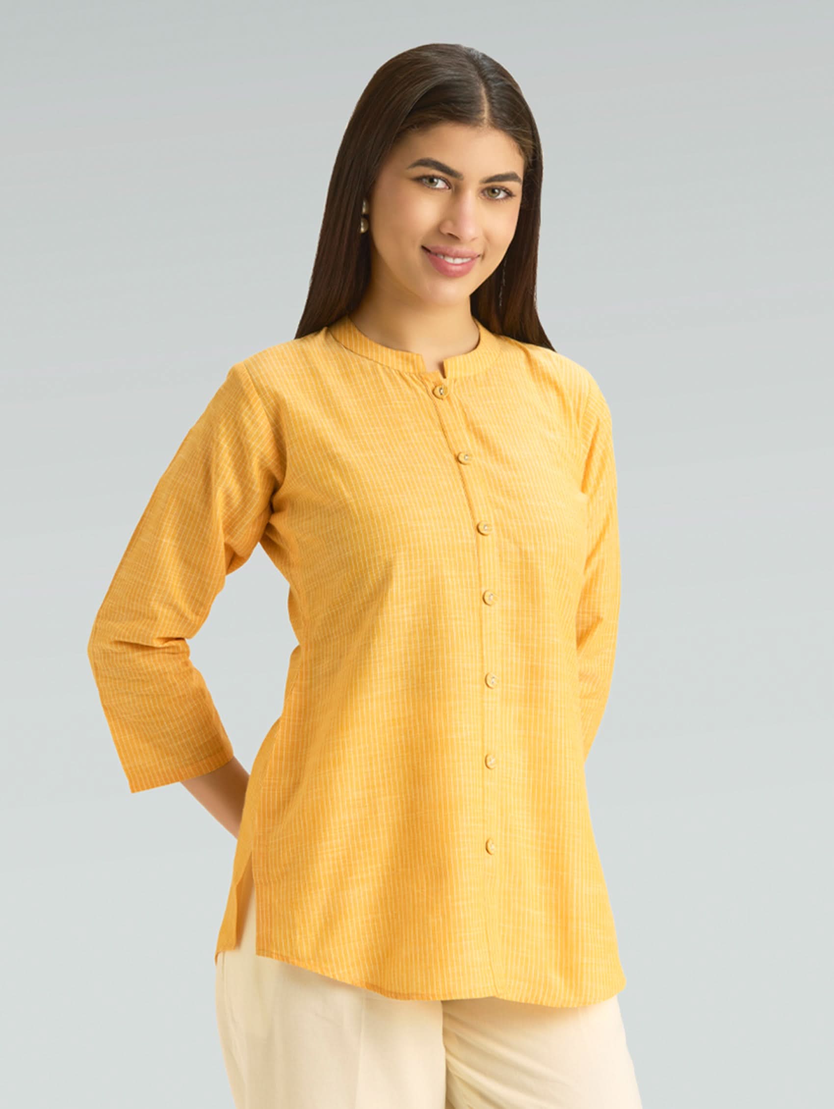 Woman wearing a yellow shirt with a plain background