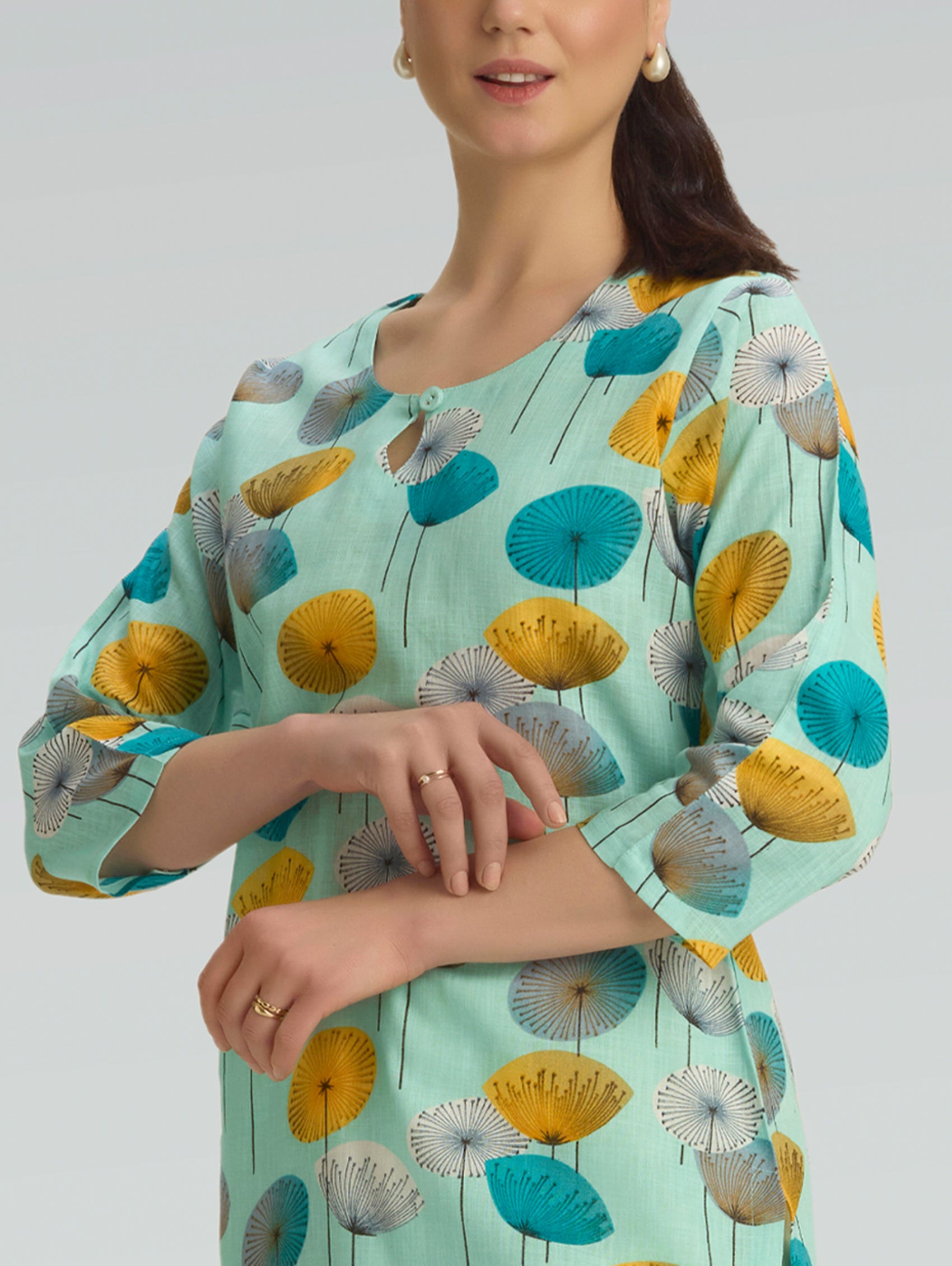 Close-up of artistic floral print on mint green cotton linen kurta fabric