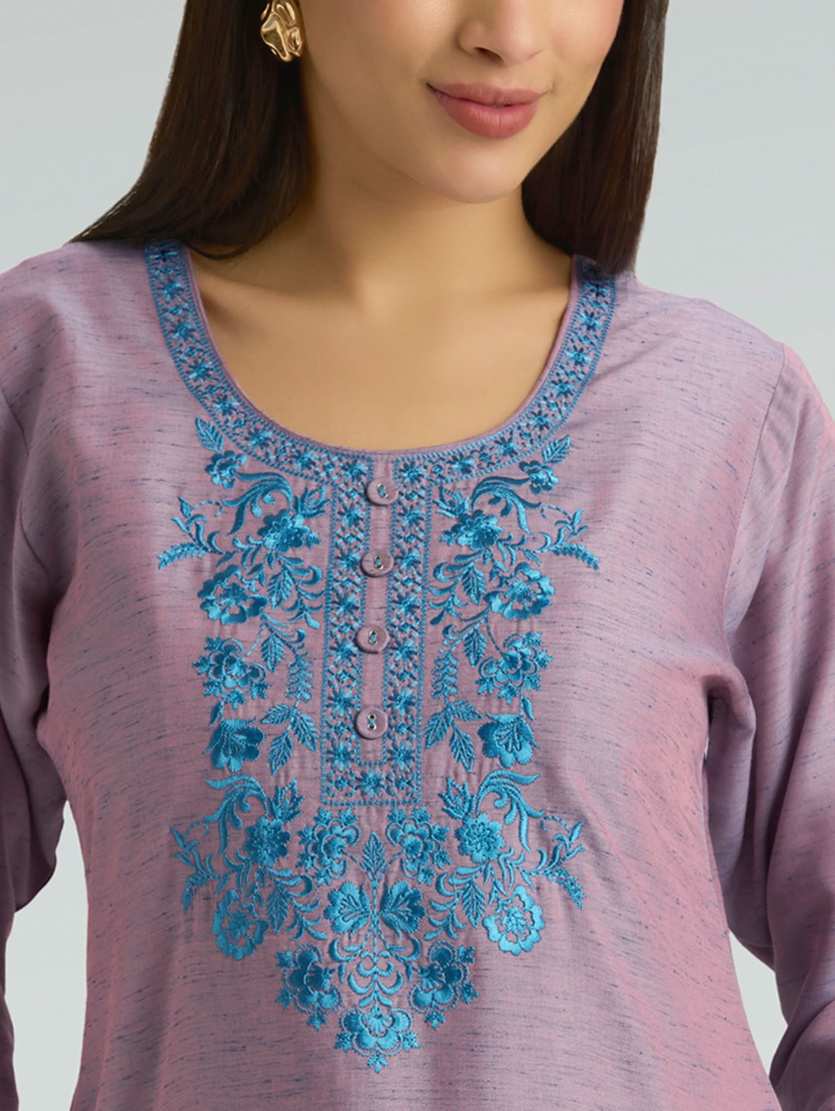 Purple top with blue floral embroidery on a plain background