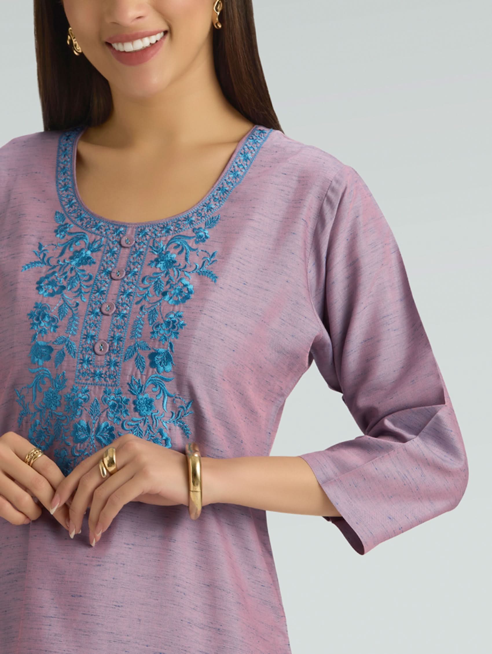 Purple top with blue embroidery on a gray background