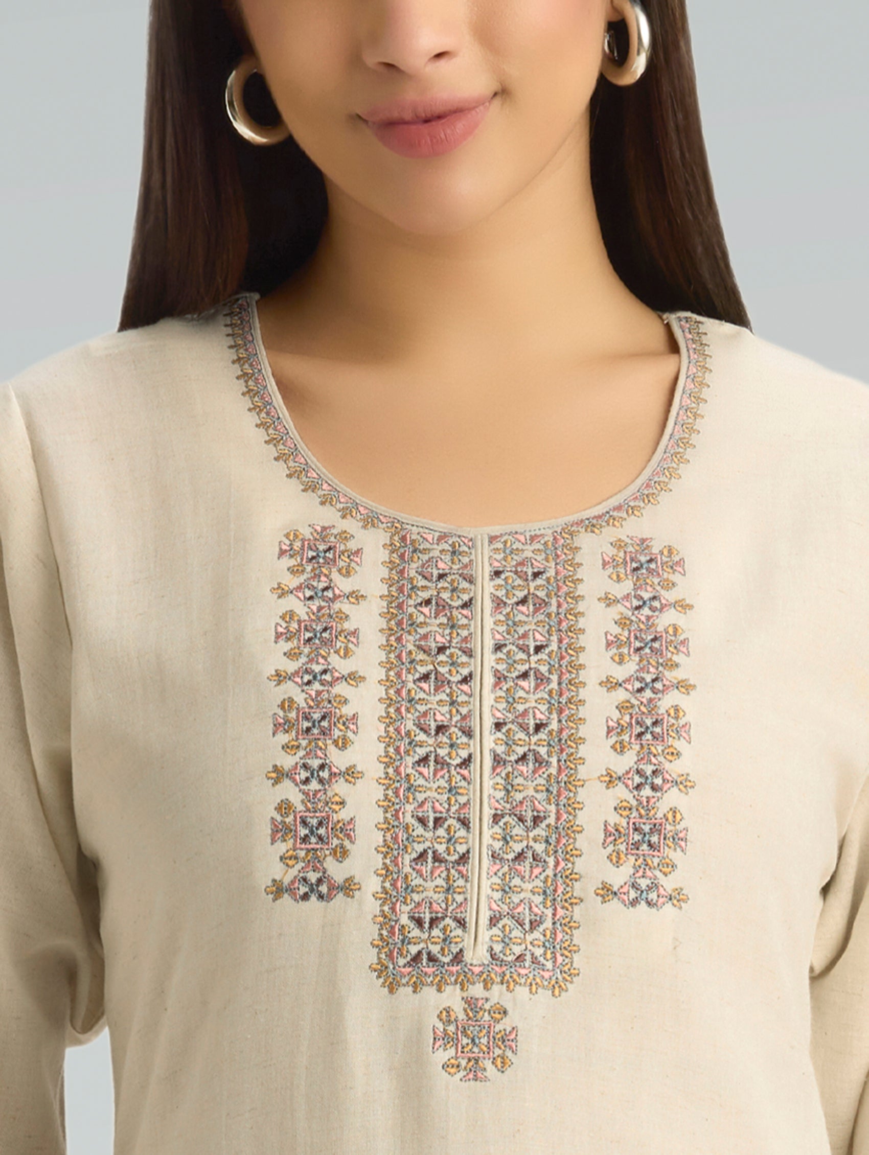 Beige kurta with intricate embroidery on a plain background