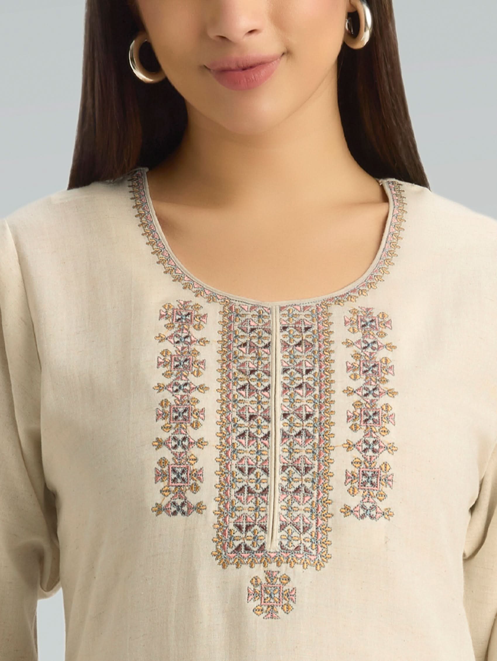 Beige kurta with intricate embroidery on a plain background