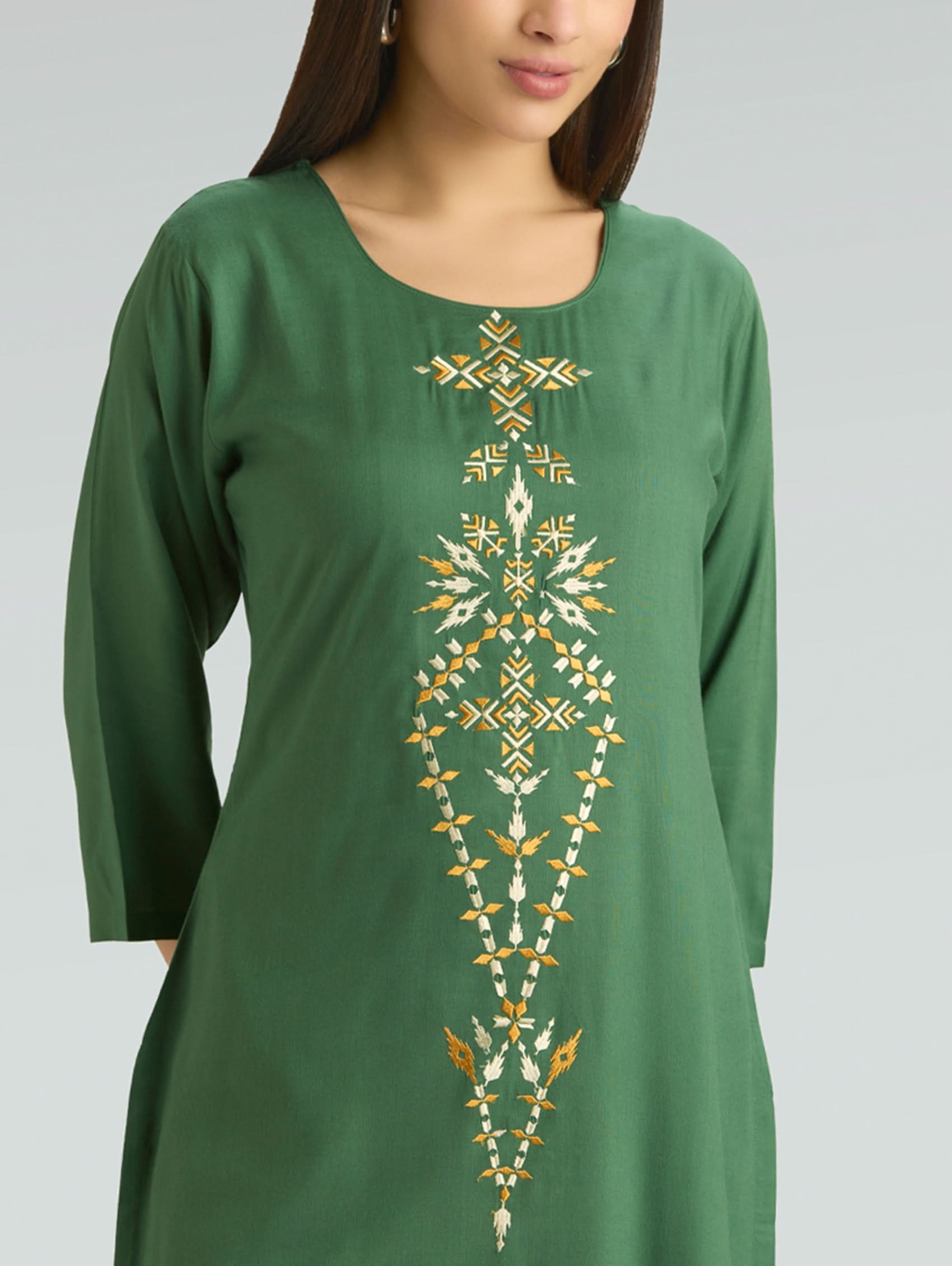 Green dress with gold embroidery on a plain background