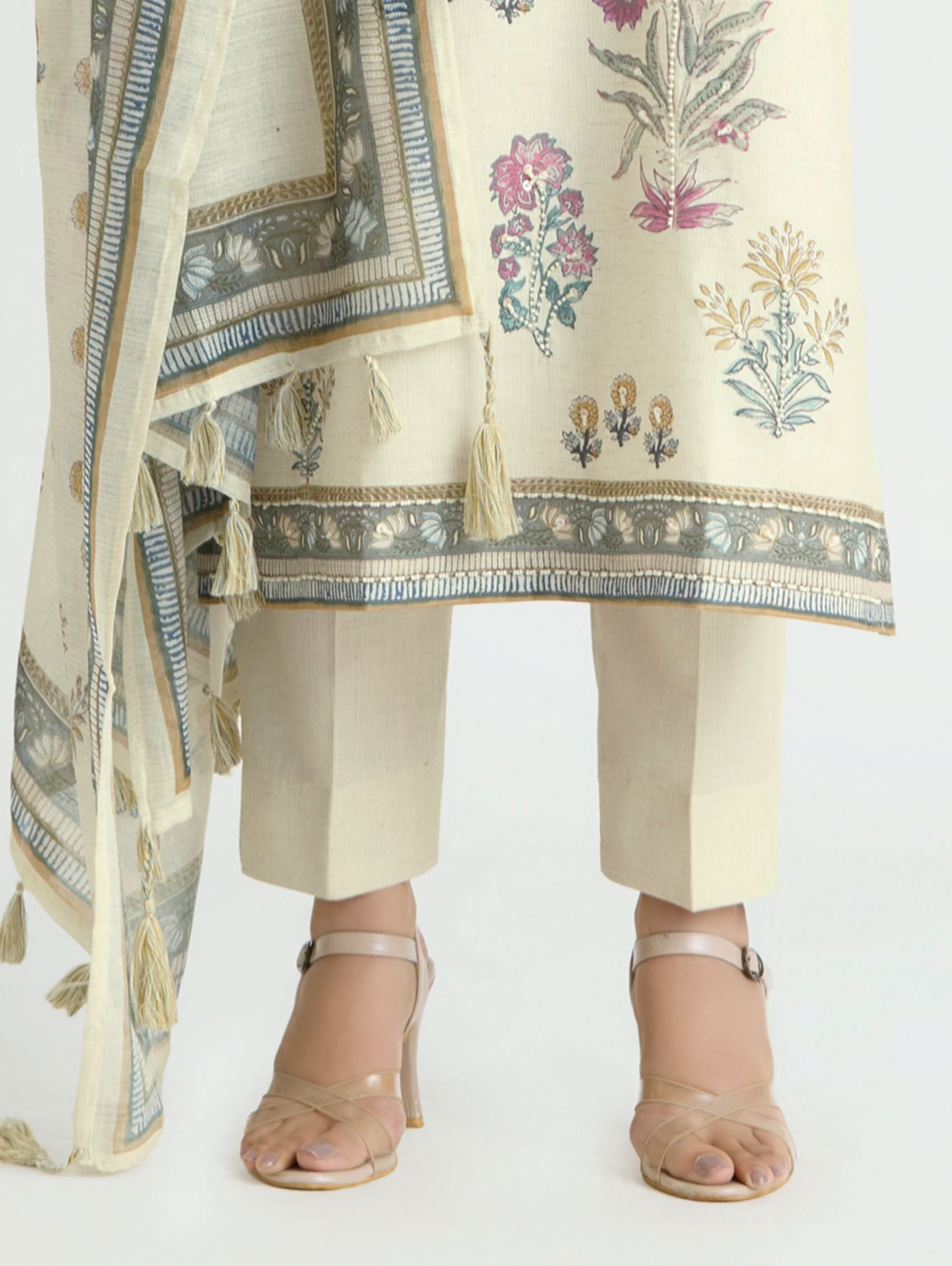 Person wearing a traditional outfit with floral patterns and a matching dupatta on a white background