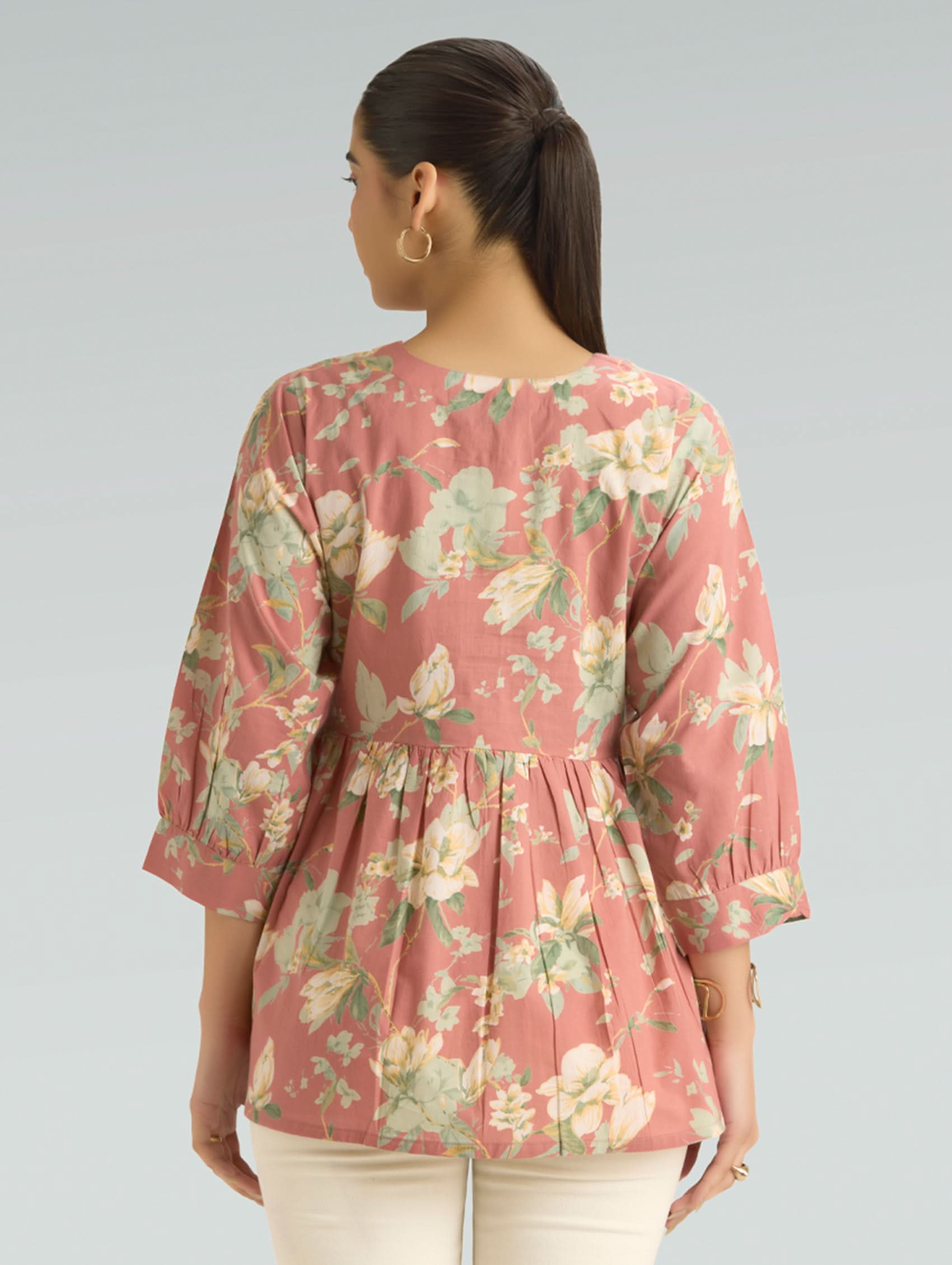 Woman wearing a floral blouse with a plain background