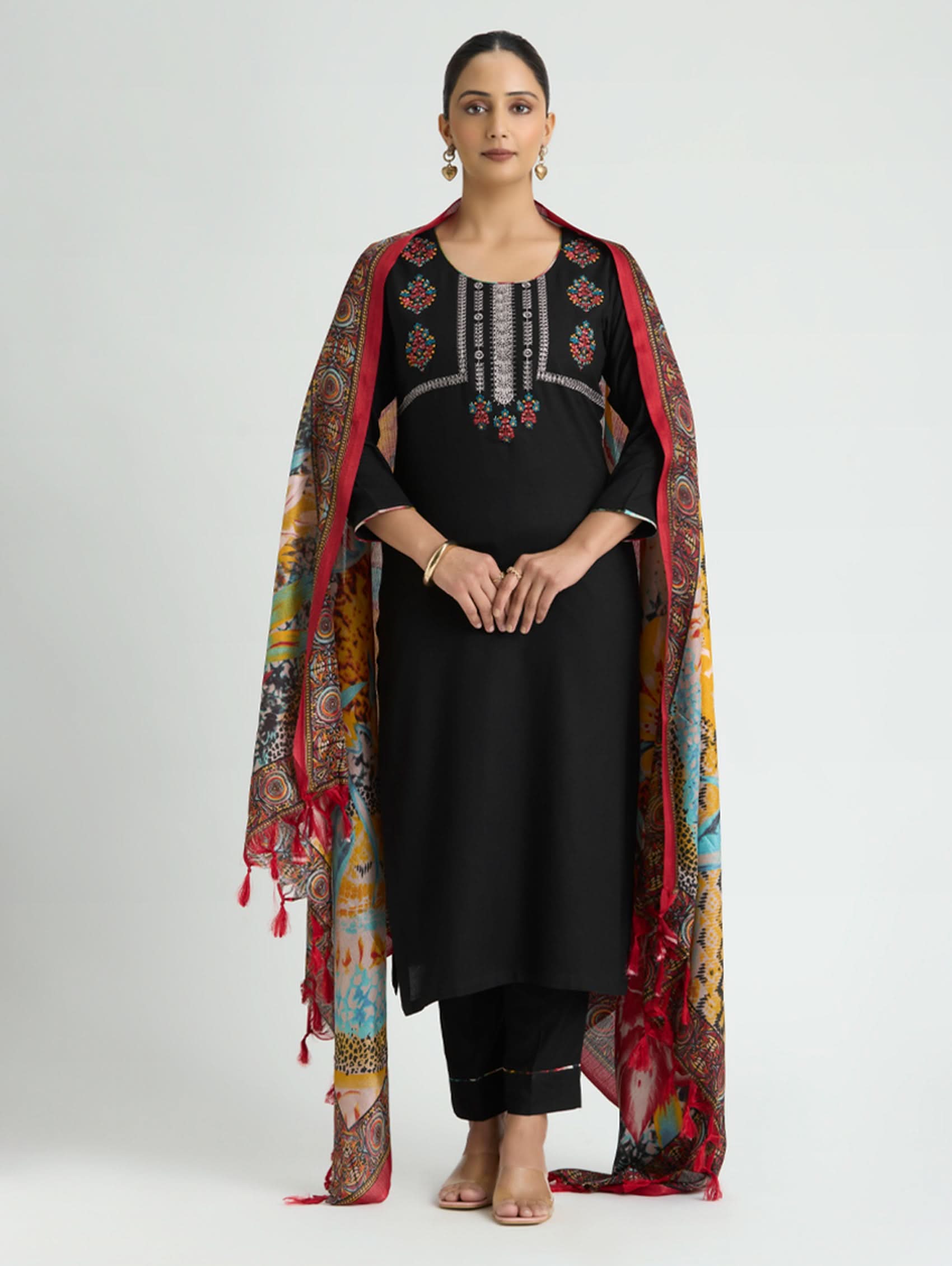 Woman wearing a black outfit with a colorful dupatta on a white background