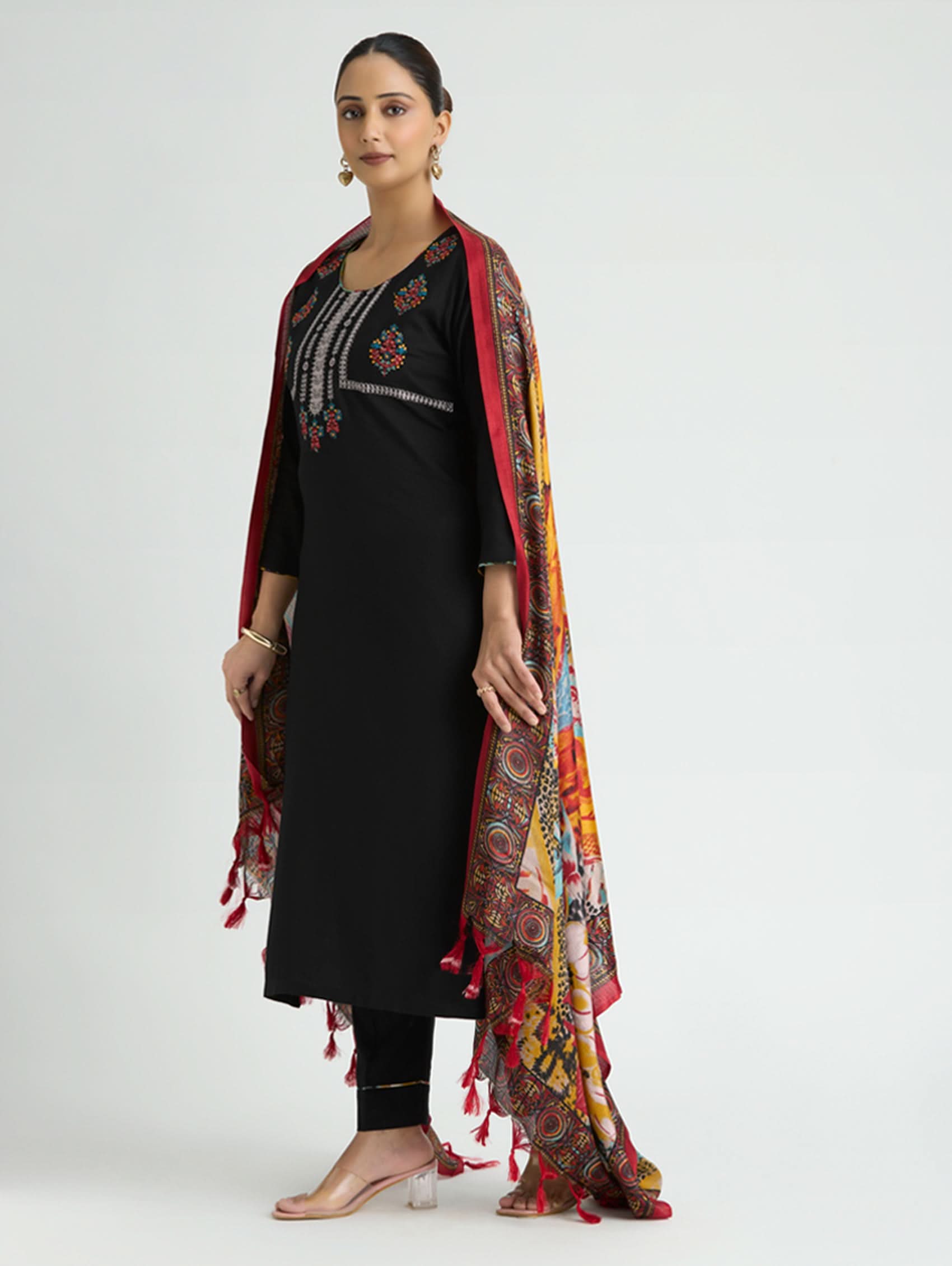 Woman wearing a black outfit with a colorful scarf on a white background