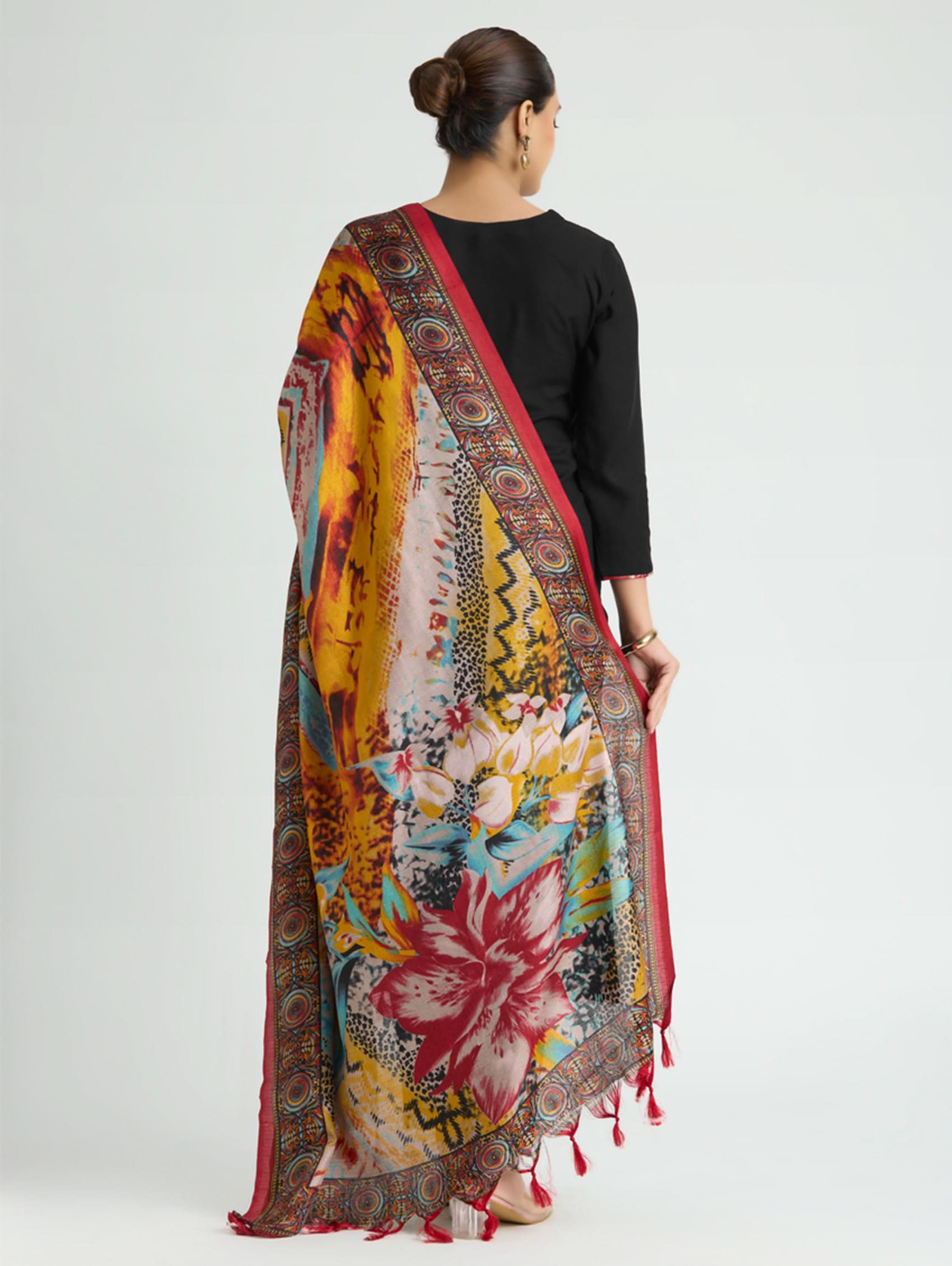 Woman wearing a colorful floral saree with a black blouse on a white background