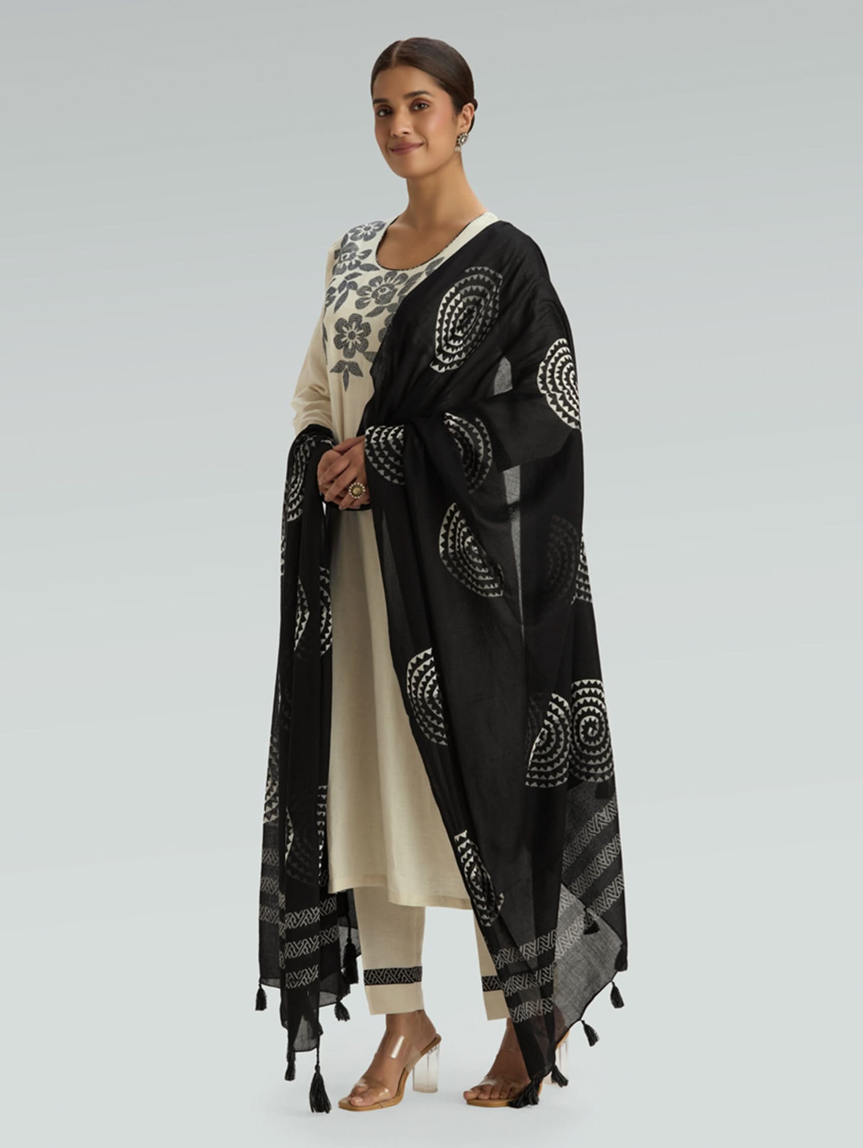 Woman wearing a black and white patterned scarf on a light gray background