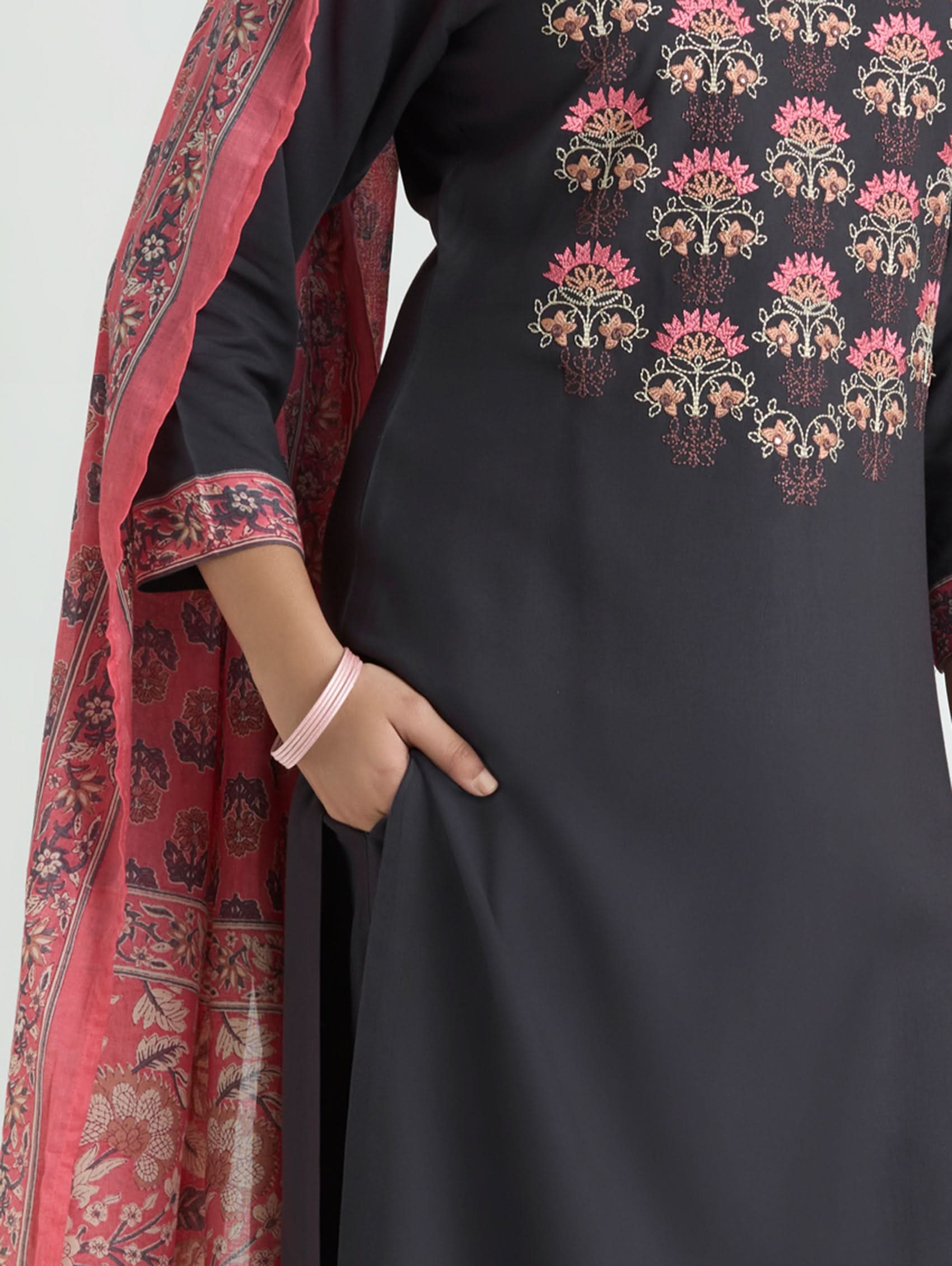 Black dress with floral embroidery and a red scarf with pattern