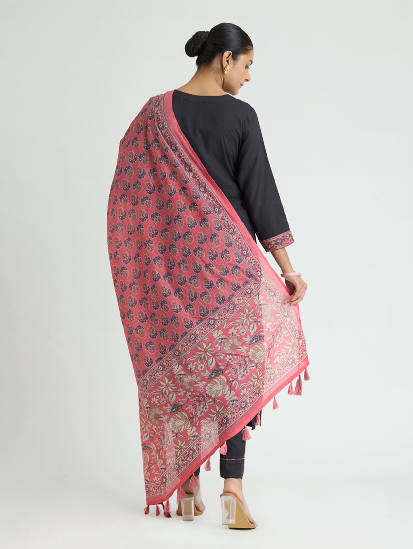Woman wearing a pink patterned scarf on a white background
