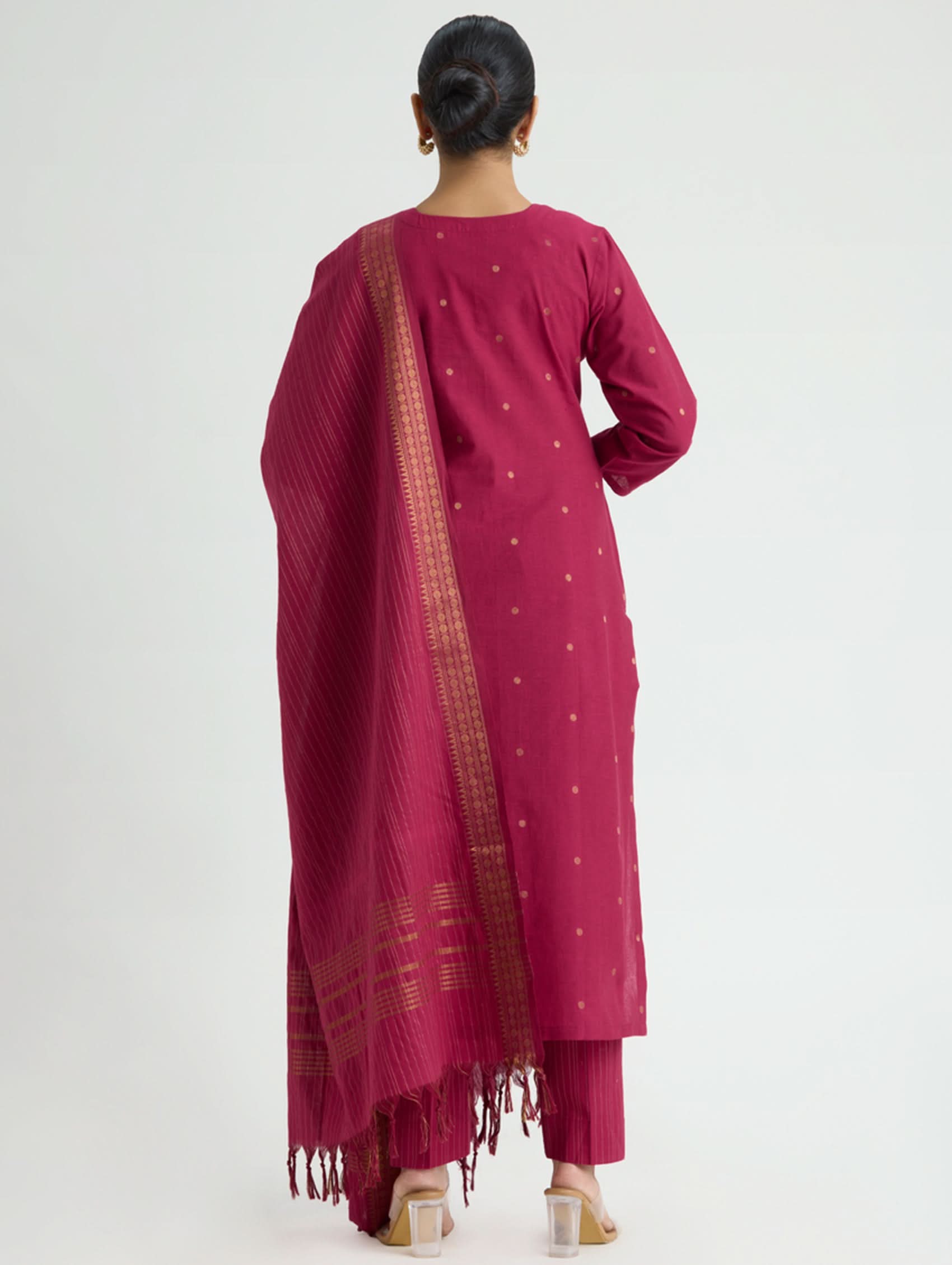 Woman wearing a maroon traditional outfit with a saree on a white background