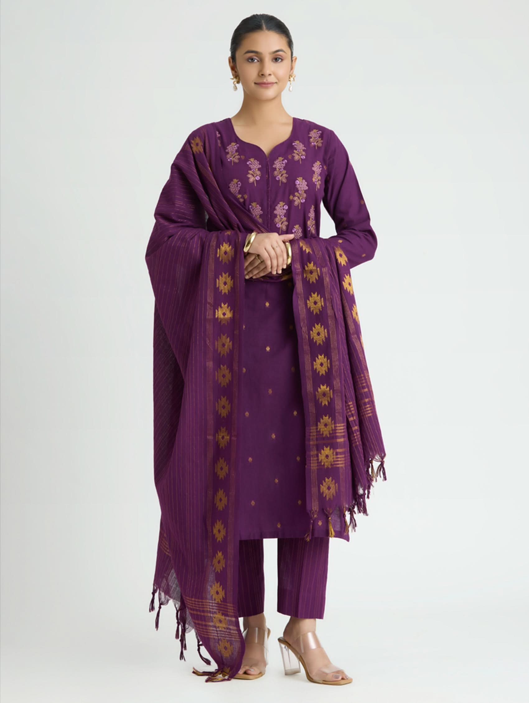Woman wearing a purple traditional outfit with a matching dupatta on a white background