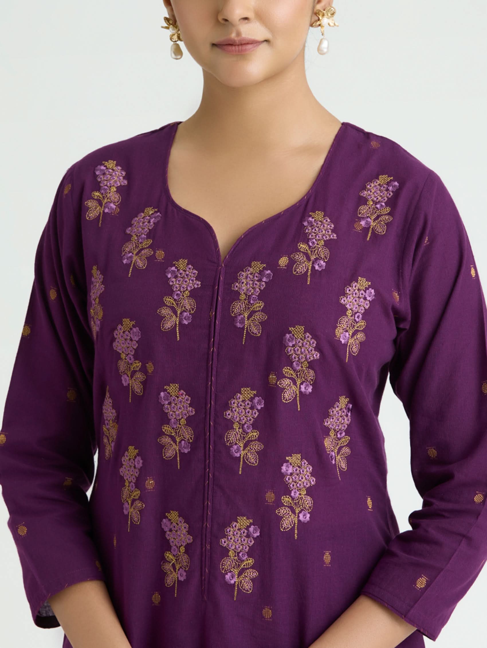Purple embroidered top worn by a model on a white background