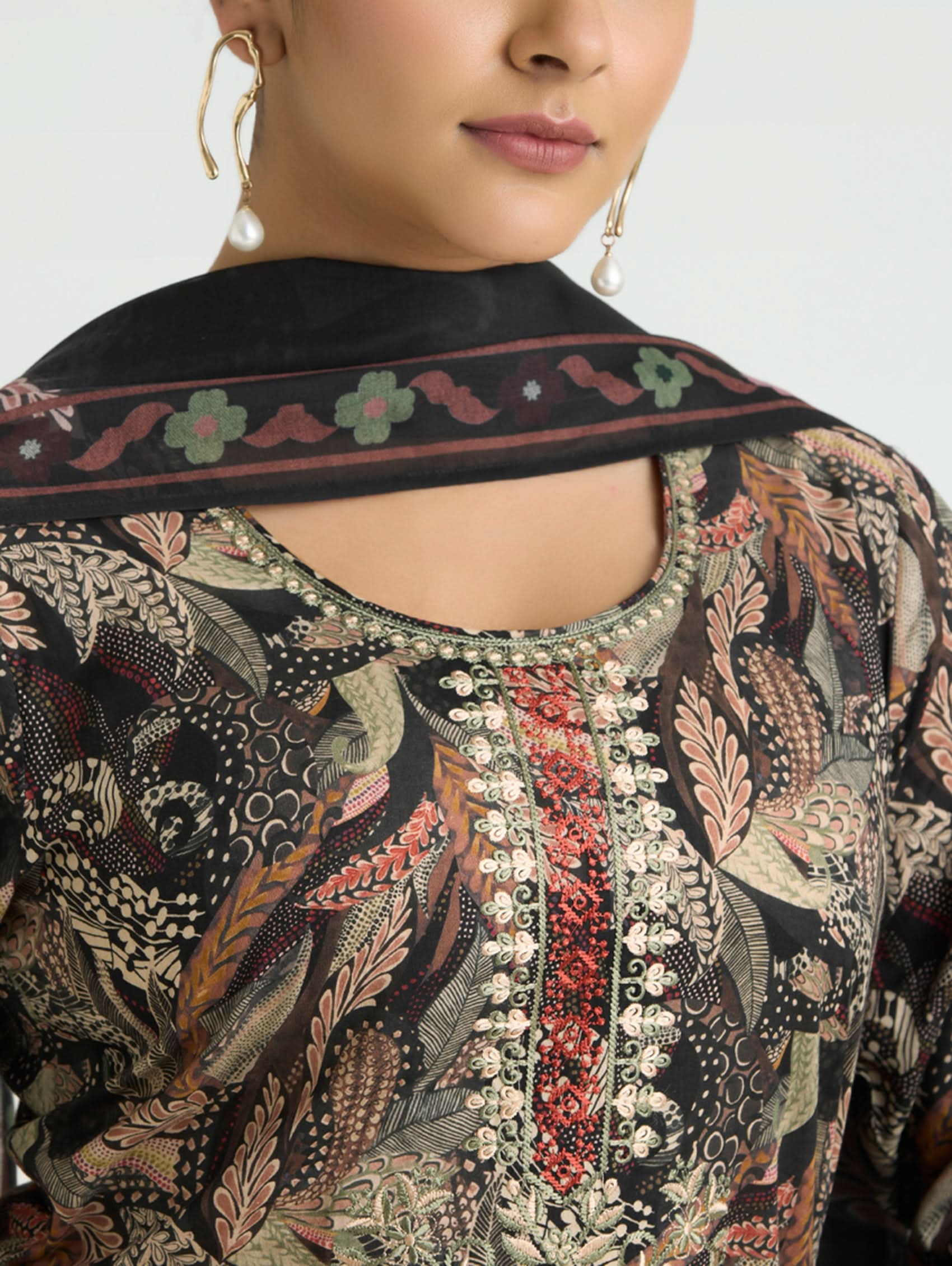 Close-up of a person wearing a patterned garment with intricate designs.