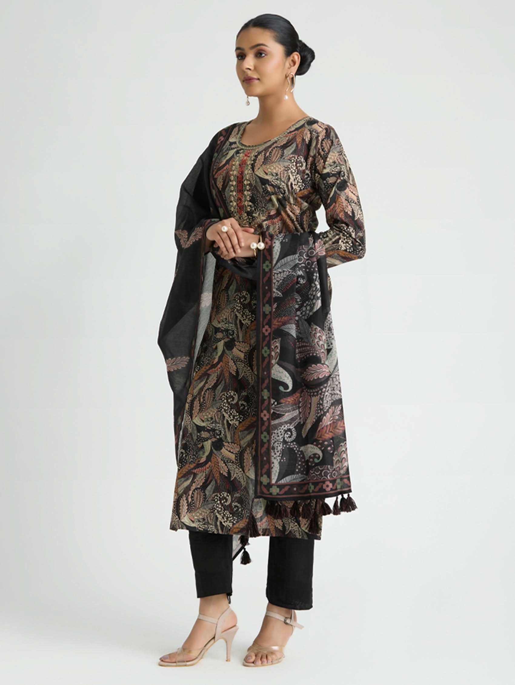 Woman wearing a patterned kurta with a black dupatta on a white background