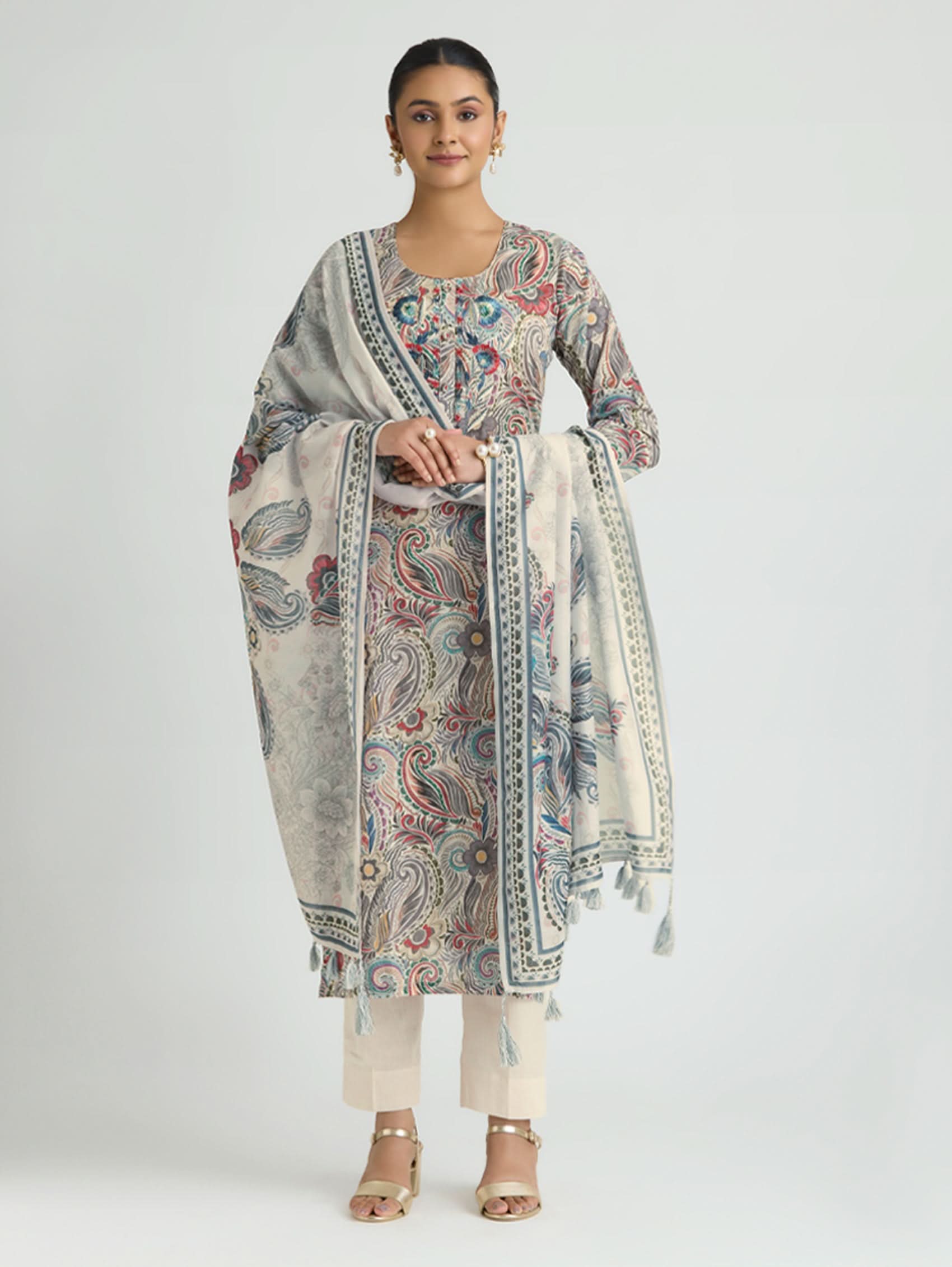Woman wearing a traditional outfit with a patterned dupatta on a white background